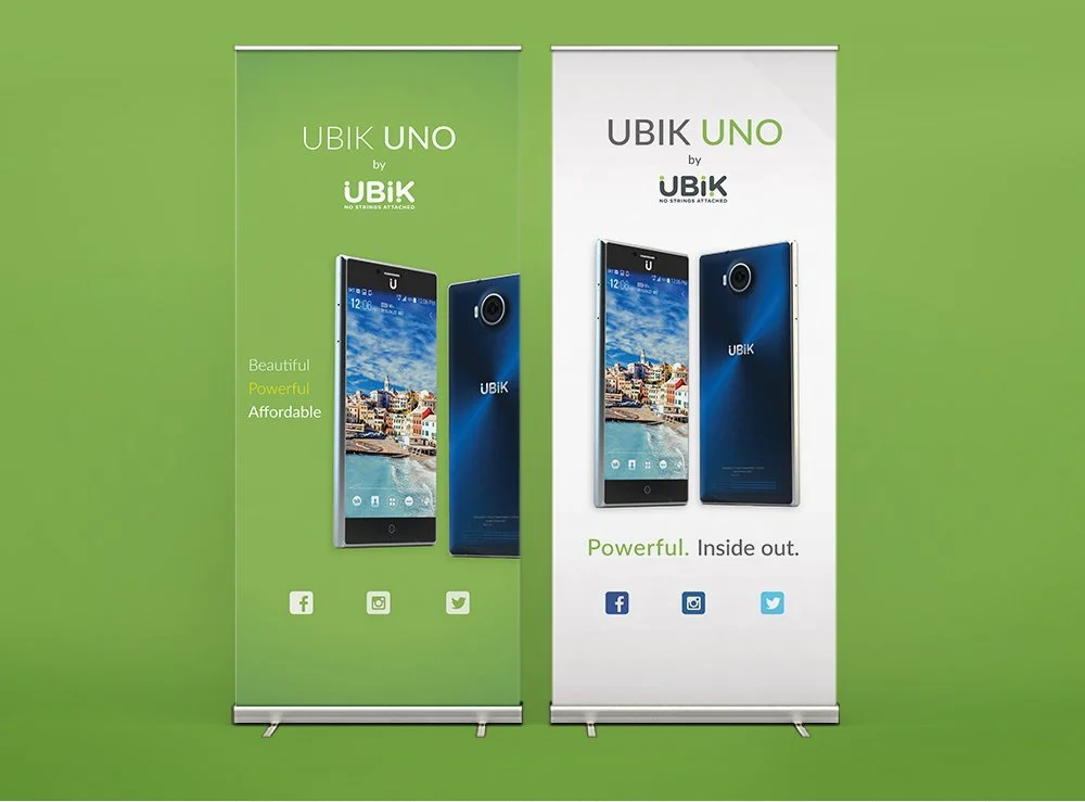 Two roll-up banners showcasing the UBIK UNO smartphone against a green background. The left banner is green and features a front and back view of the phone, with the words 'Beautiful, Powerful, Affordable' on the side. The right banner is white, with the same images of the phone and the phrase 'Powerful. Inside out.' Below the images are social media icons for Facebook, Instagram, and Twitter.