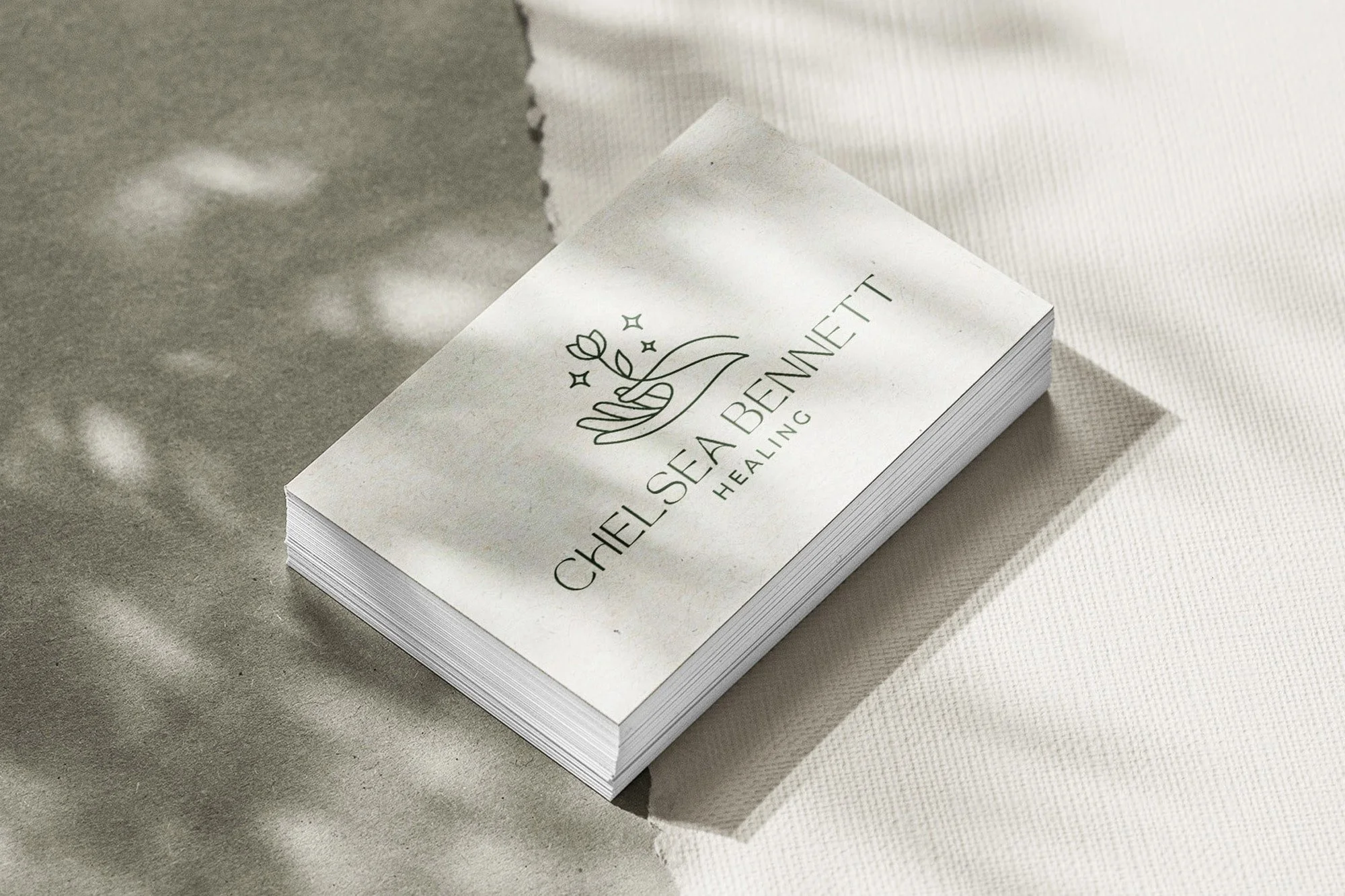 Business card for Chelsea Sea Bennett Healing with a minimalist design, featuring a hand holding a flower and sparkles.