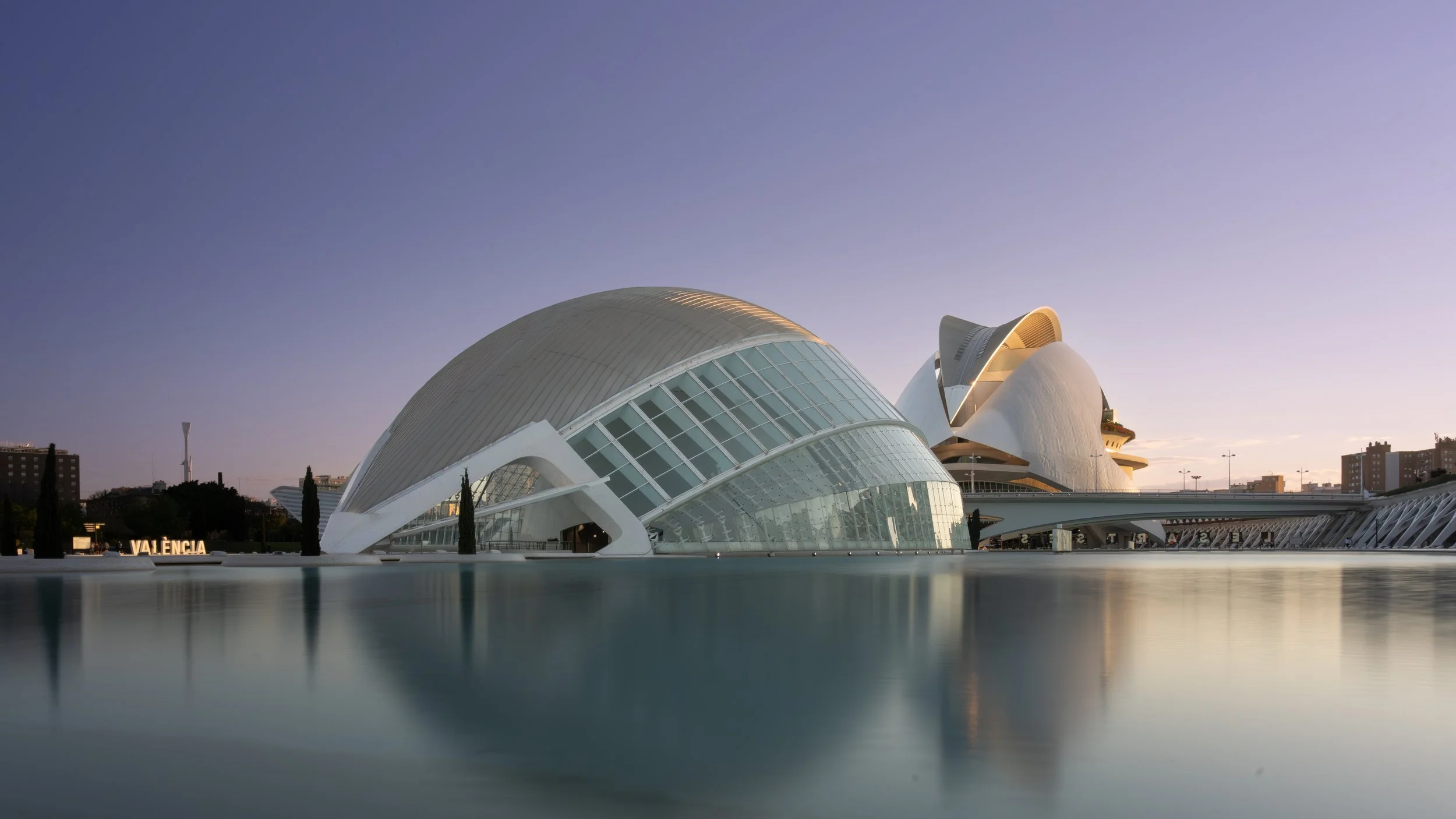 L'Hemisfèric in Valencia ,,the "eye of wisdom," designed by Santiago Calatrava, part of the City of Arts and Sciences, featuring a planetarium, IMAX cinema, and laserium, surrounded by a large reflecting pool, with its "eyelids" opening and closing f