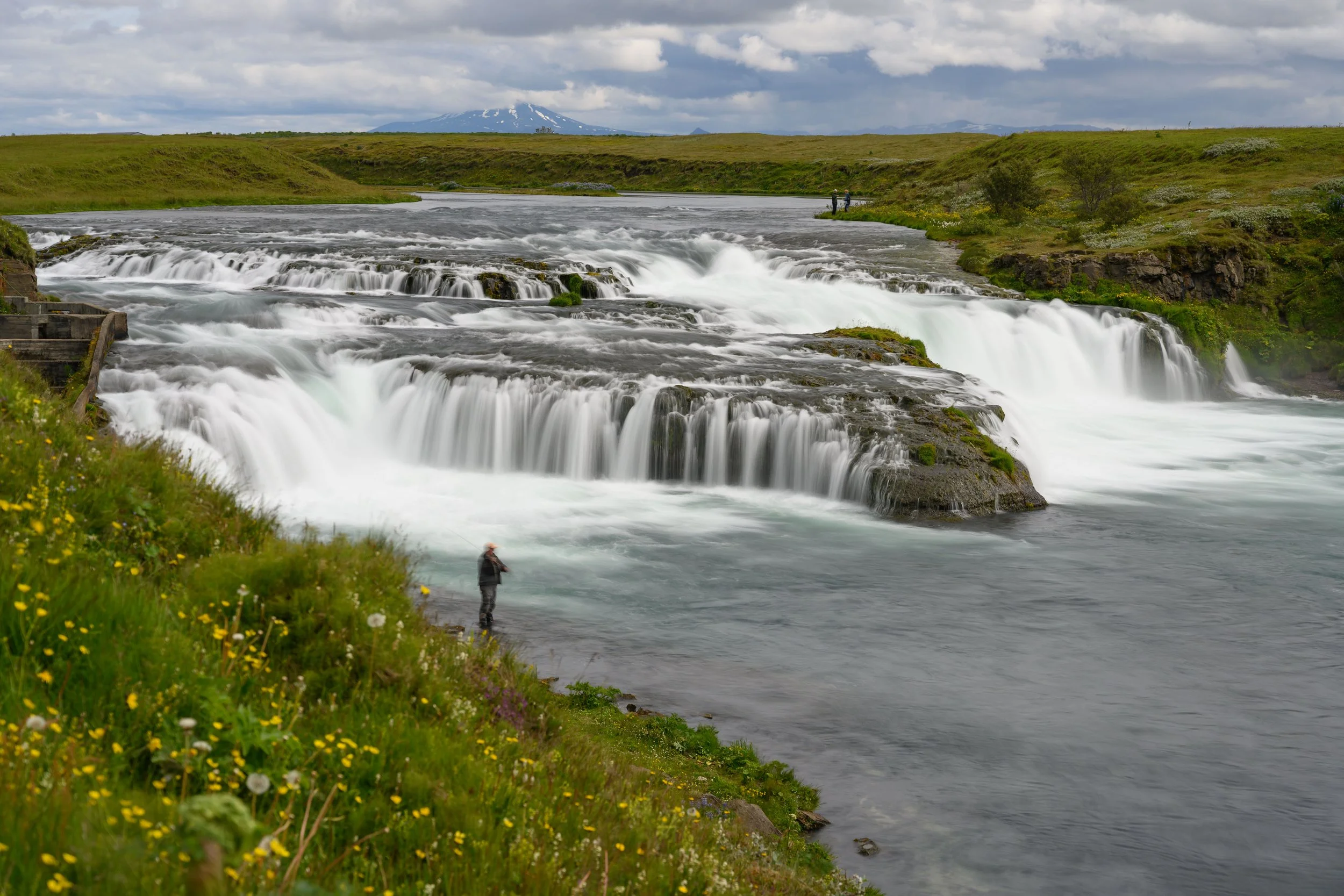 Ægissíðufoss is a picturesque, modest, and wide waterfall in southern Iceland on the Ytri-Rangá river, near the town of Hella. It is known for its tranquil setting, where on a clear day, the active Hekla volcano can be seen in the background. 