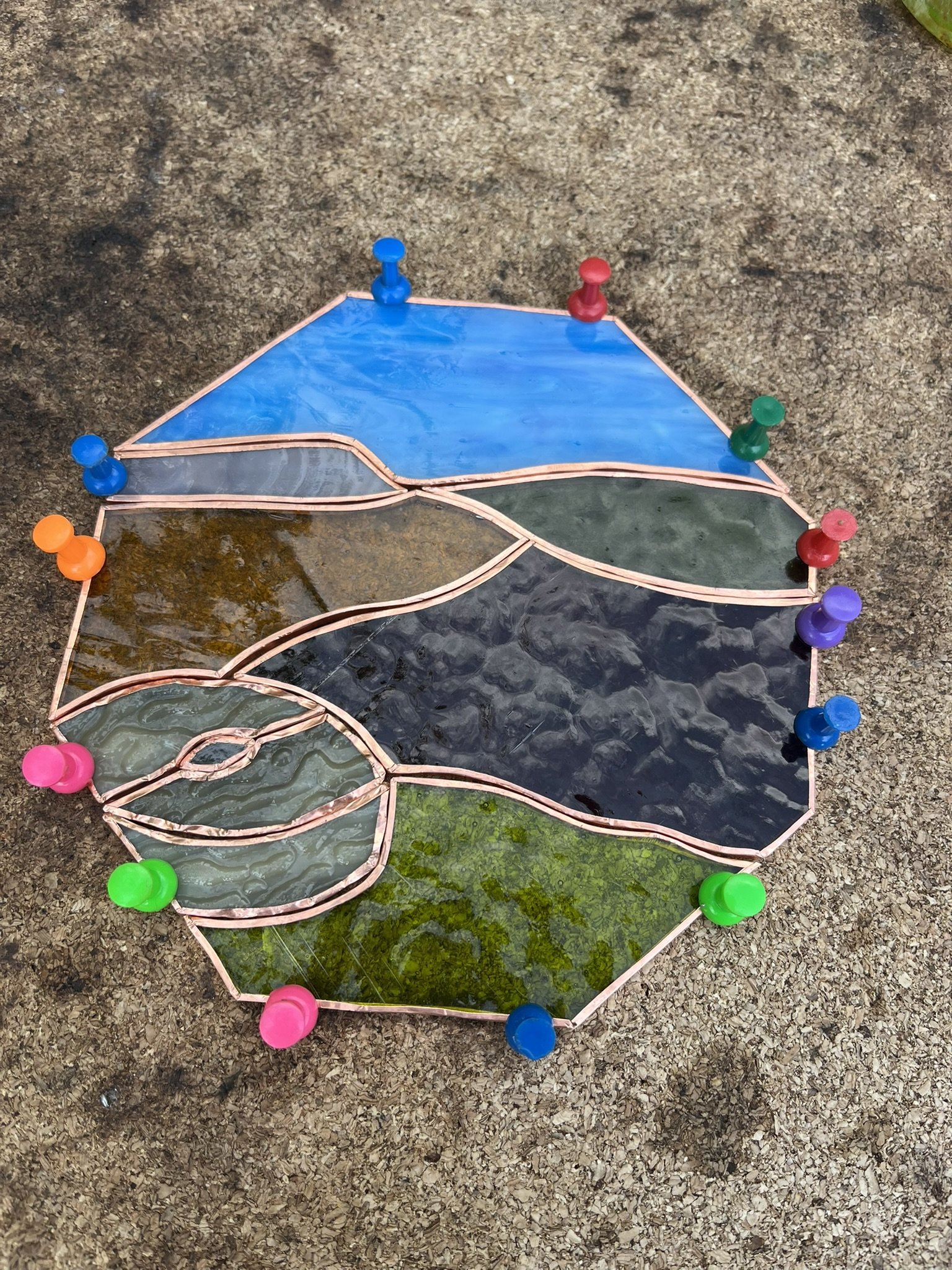 My Peak District millstone landscape foiled and pinned to a corkboard ready for soldering.