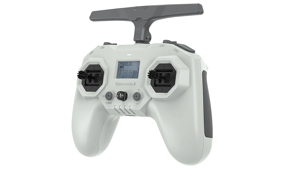 A white drone remote control with two joysticks, a small display screen, and several buttons, with a black handle on top.