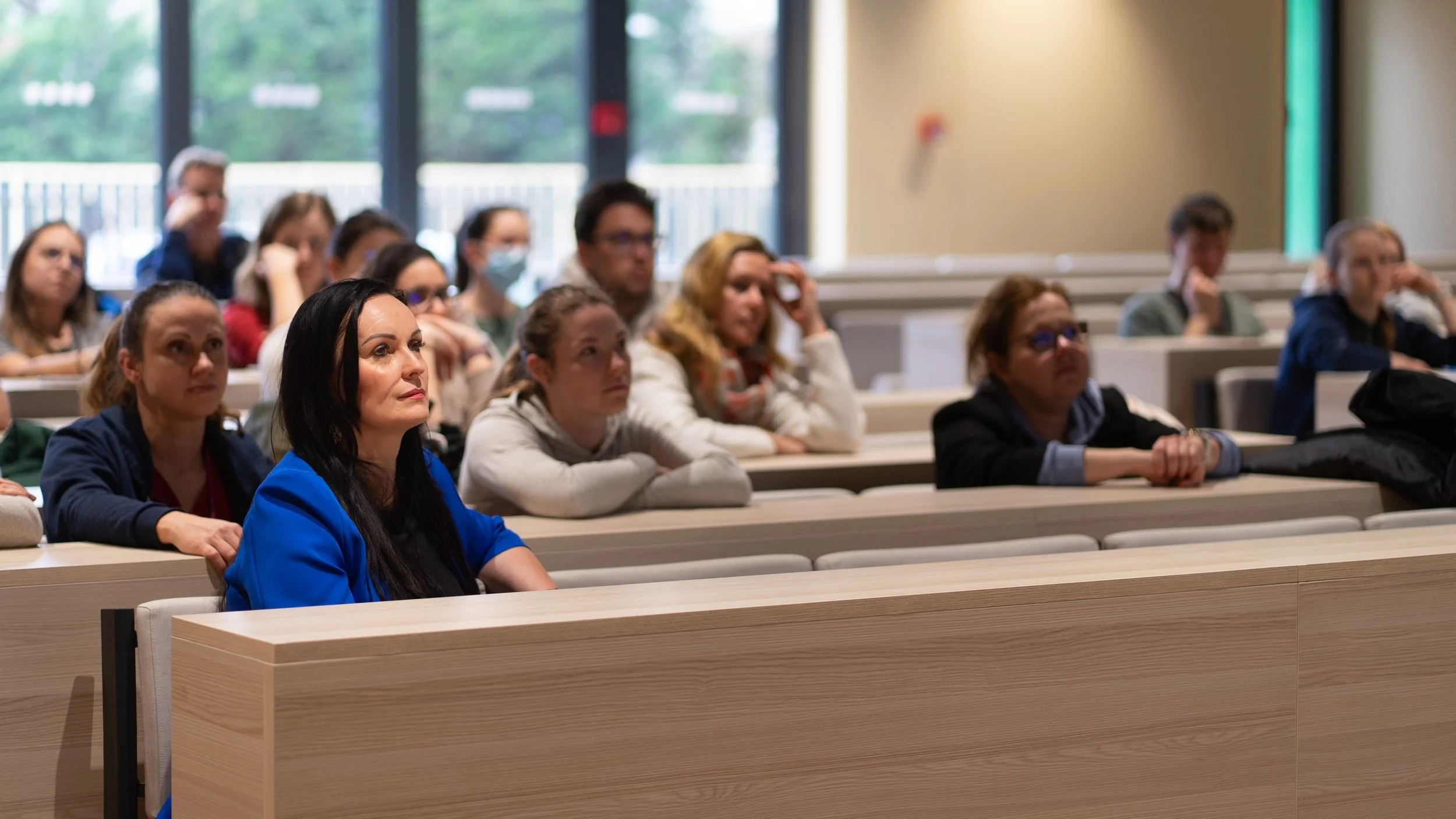 People sitting in a classroom or lecture hall listening attentively to a presentation.