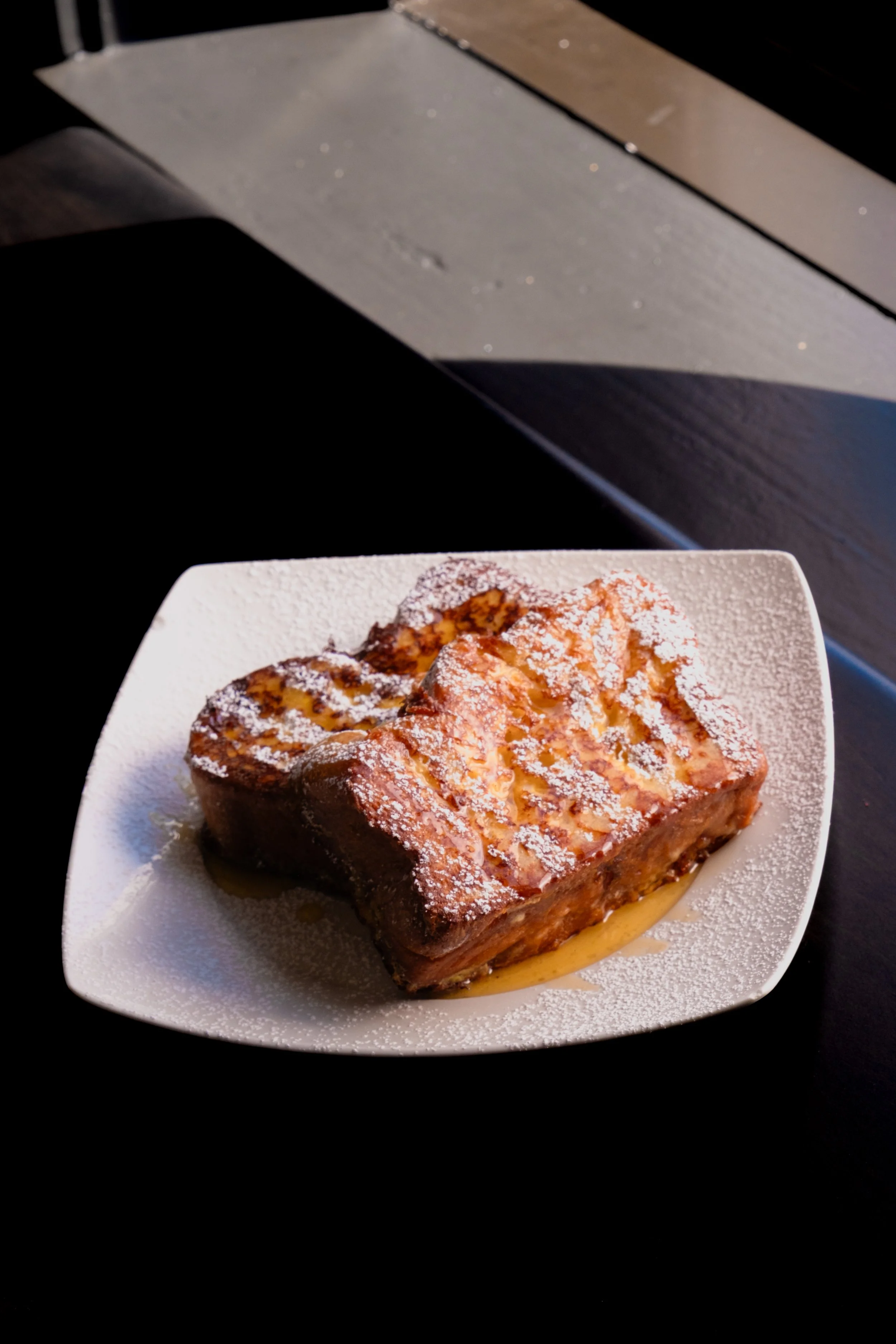 French toast on housemade brioche bread drizzled with maple syrup and compote