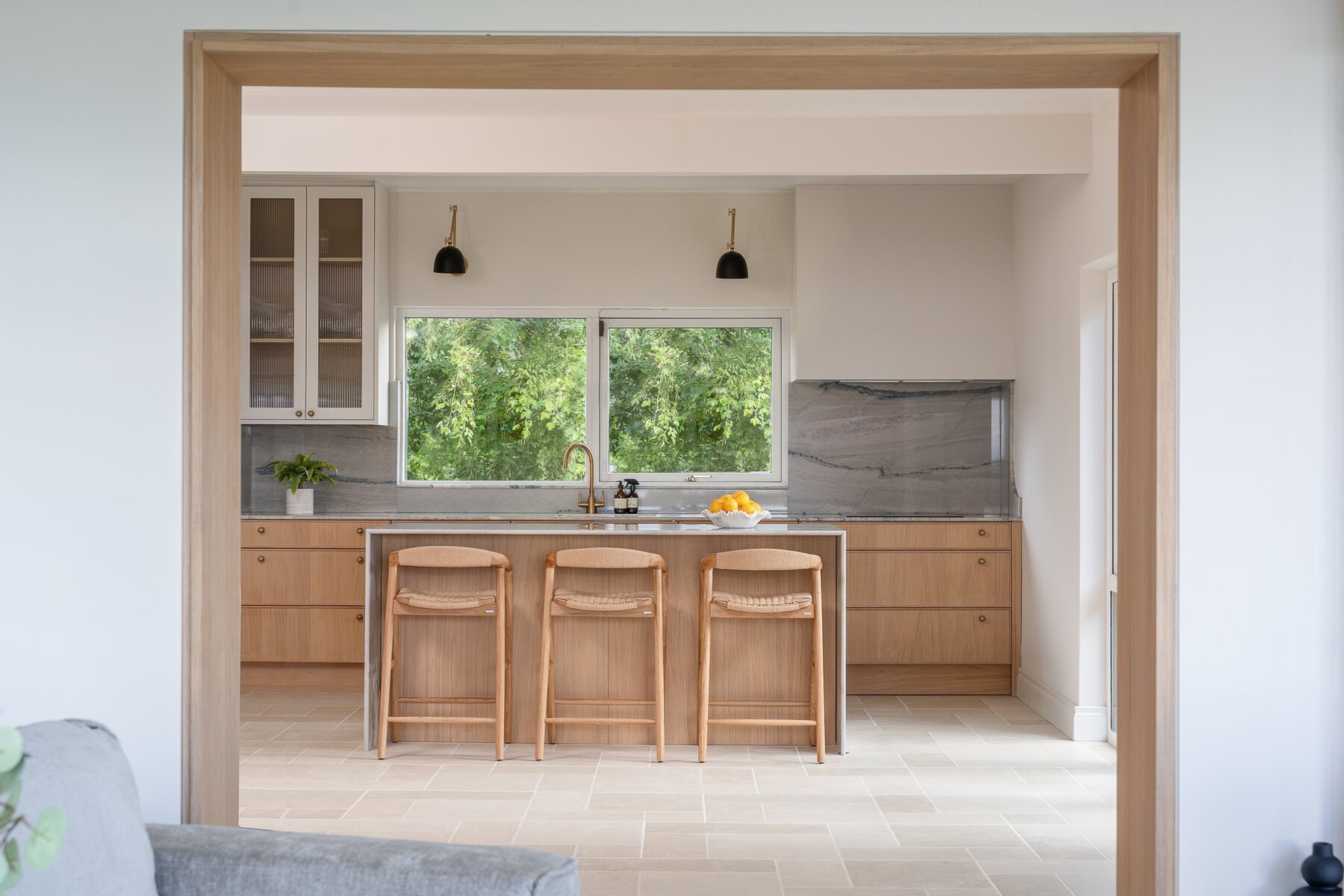 Oak kitchen viewed through a framed opening, designed and made by Royal & Co.