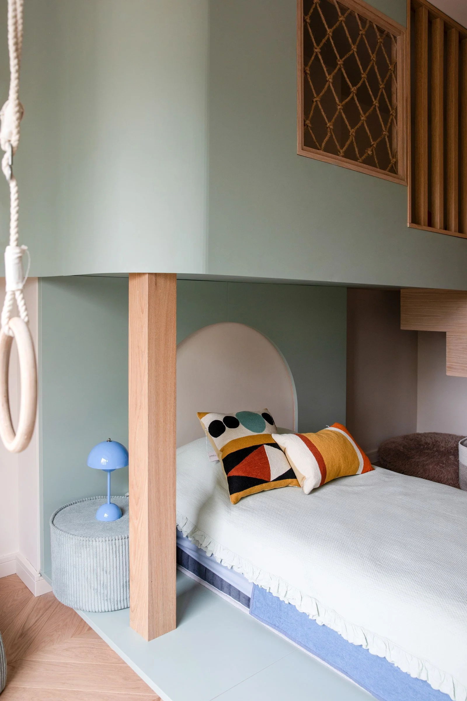 Built-in children's bed with a sage green canopy, timber trim and integrated storage.