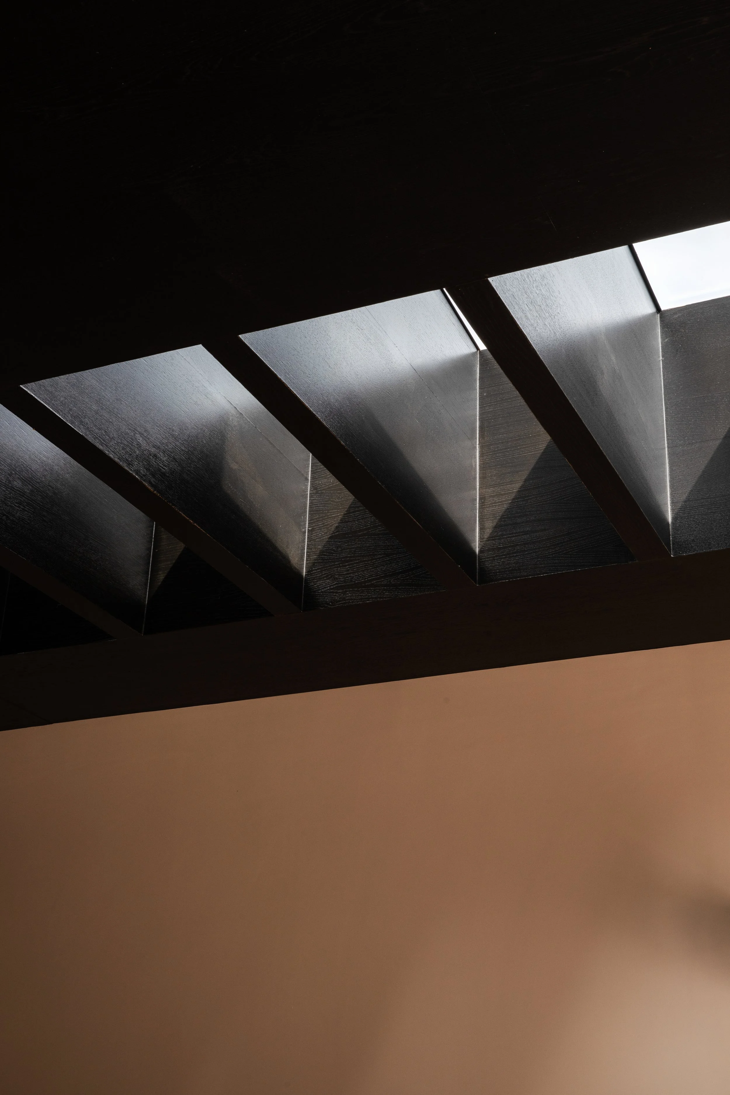 Dark timber ceiling beams and architectural detailing in a bespoke interior.