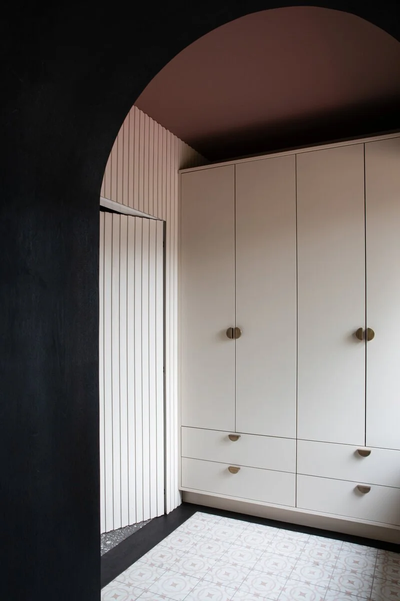 Bespoke fitted wardrobes with fluted panels, painted doors and brass knobs.