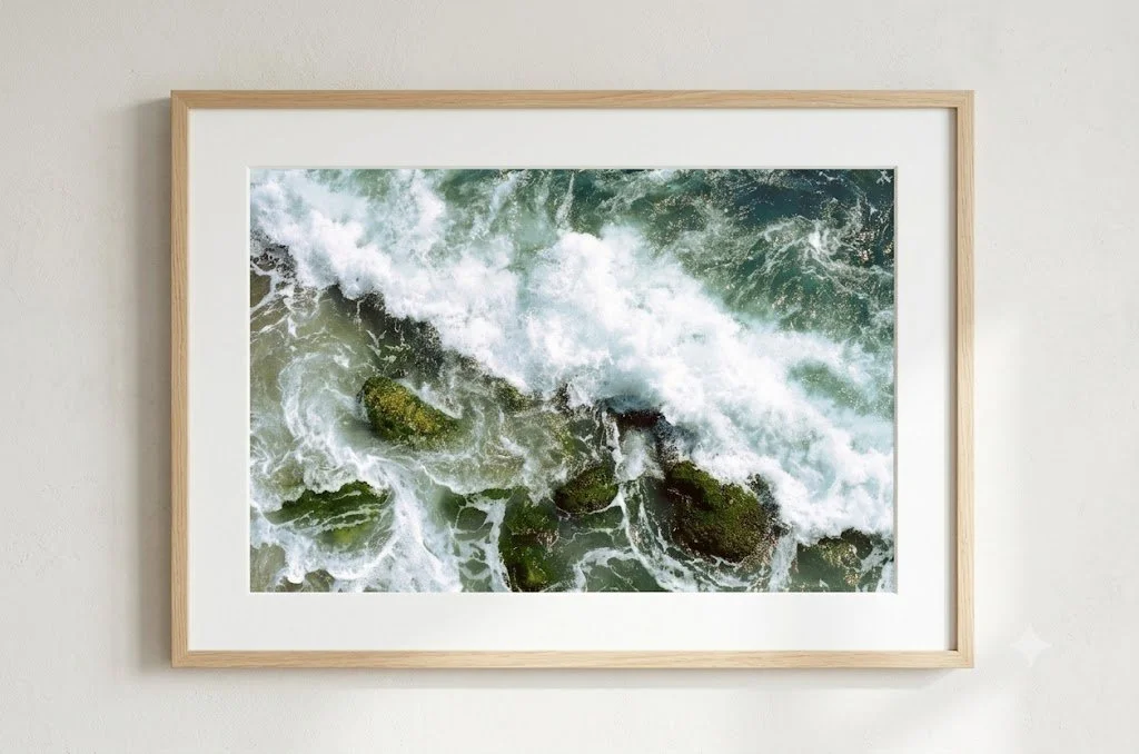 Framed aerial photograph of ocean waves crashing over rocks.