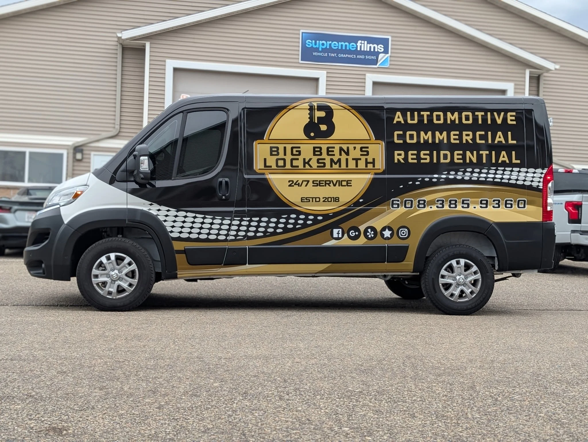 Black and gold Big Ben's Locksmith service van parked outside a building with a supreme films sign.