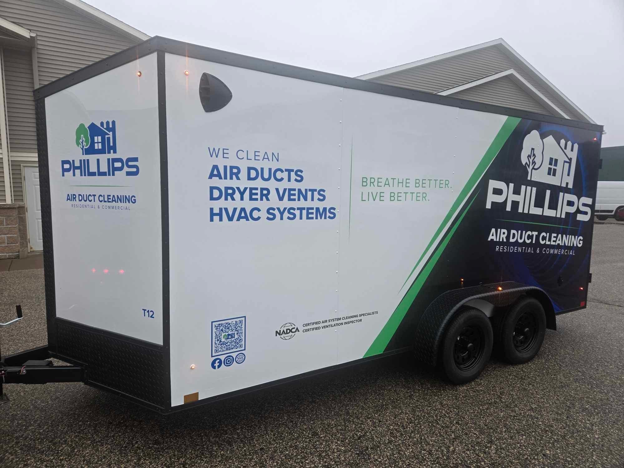 Trailer with branding for Phillips air duct cleaning services, parked outdoors on a paved surface.