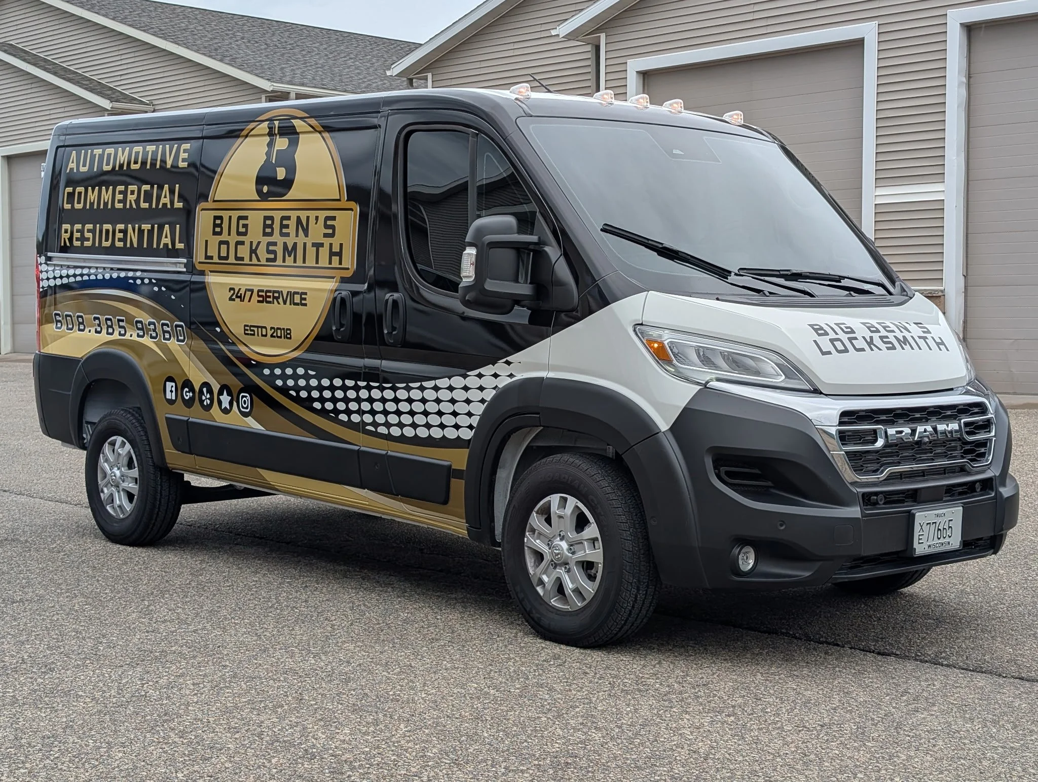 Black and white service van for Big Ben's Locksmith parked on a driveway in front of a residential garage. The van features the company logo, contact information, services offered, and social media icons.