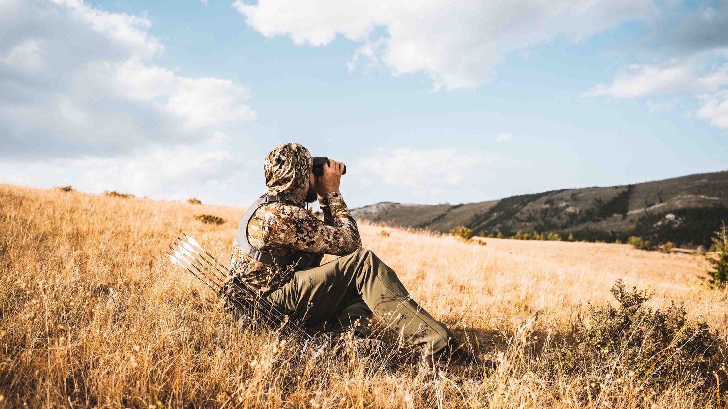 Hunter glassing from the tall grass in Montana