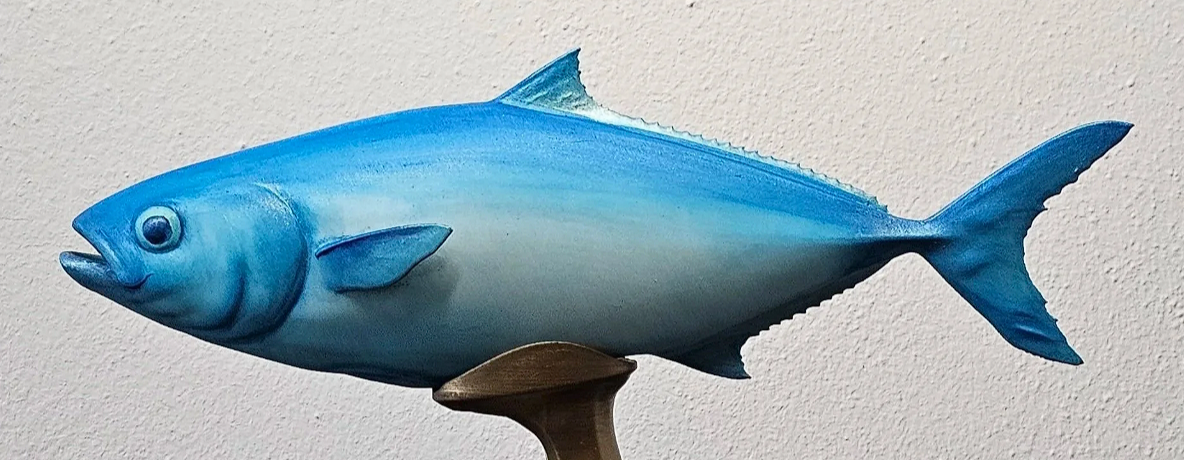 Pesce decorativo blu in mostra su una parete