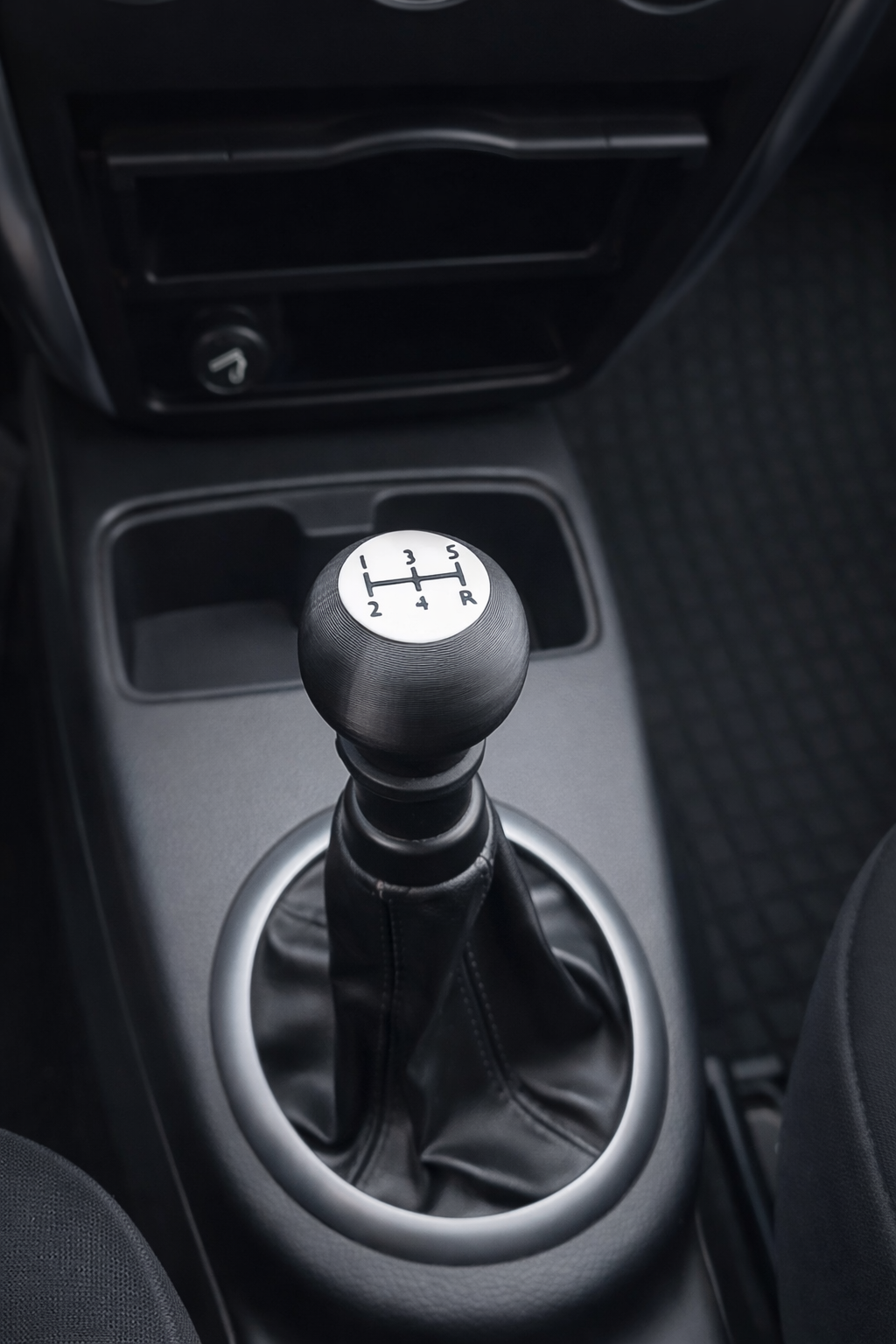 Cambio manuale dell'auto con leva del cambio in posizione neutro e una griglia di presa d'aria nell'auto.