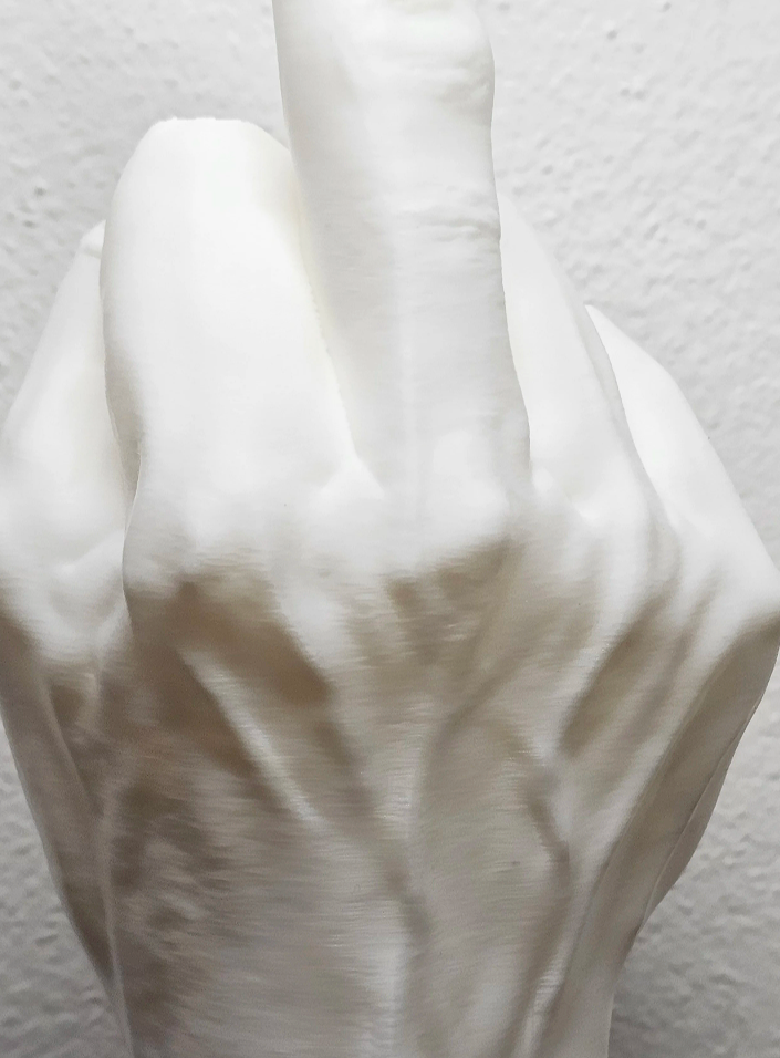 Una mano bianca con il dito medio alzato, in un gesto di sfida o insulti.