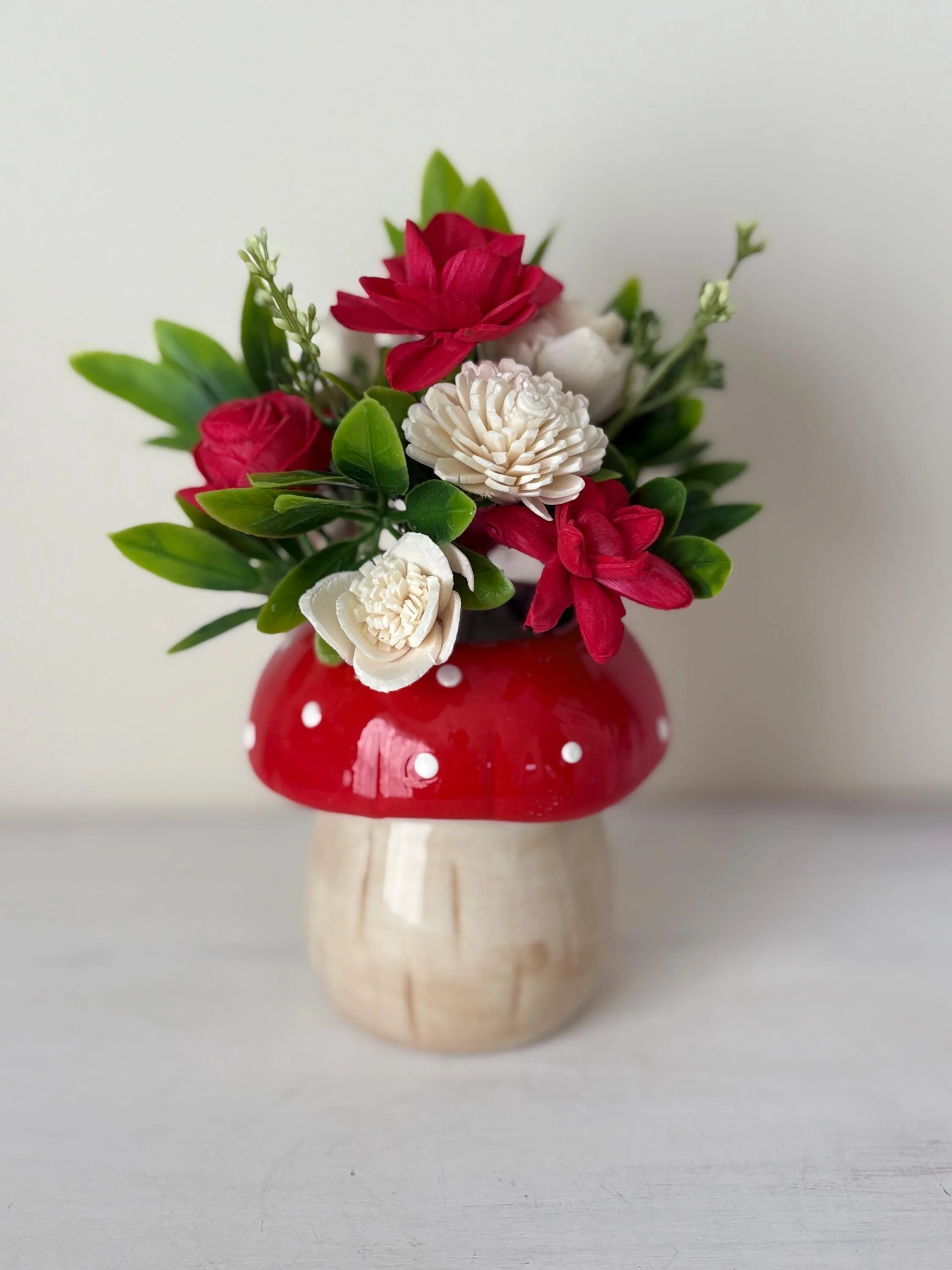 Red and white hand-painted sola wood flowers in a red spotted ceramic mushroom vase