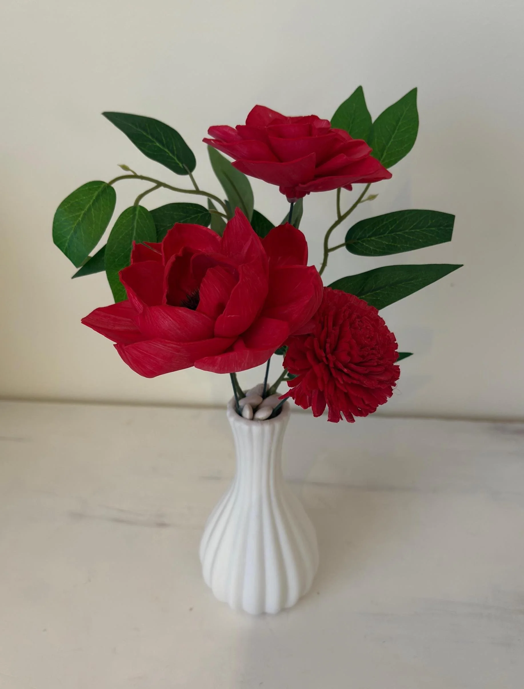 Deep red hand-painted sola wood peonies and zinnia in a white fluted ceramic bud vase