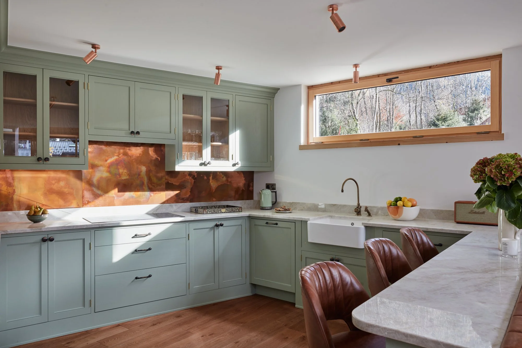 Copper splashback complemented by Calcatta gold marble worktops and sage green cabinets create a gorgeous modern bespoke kitchen. 