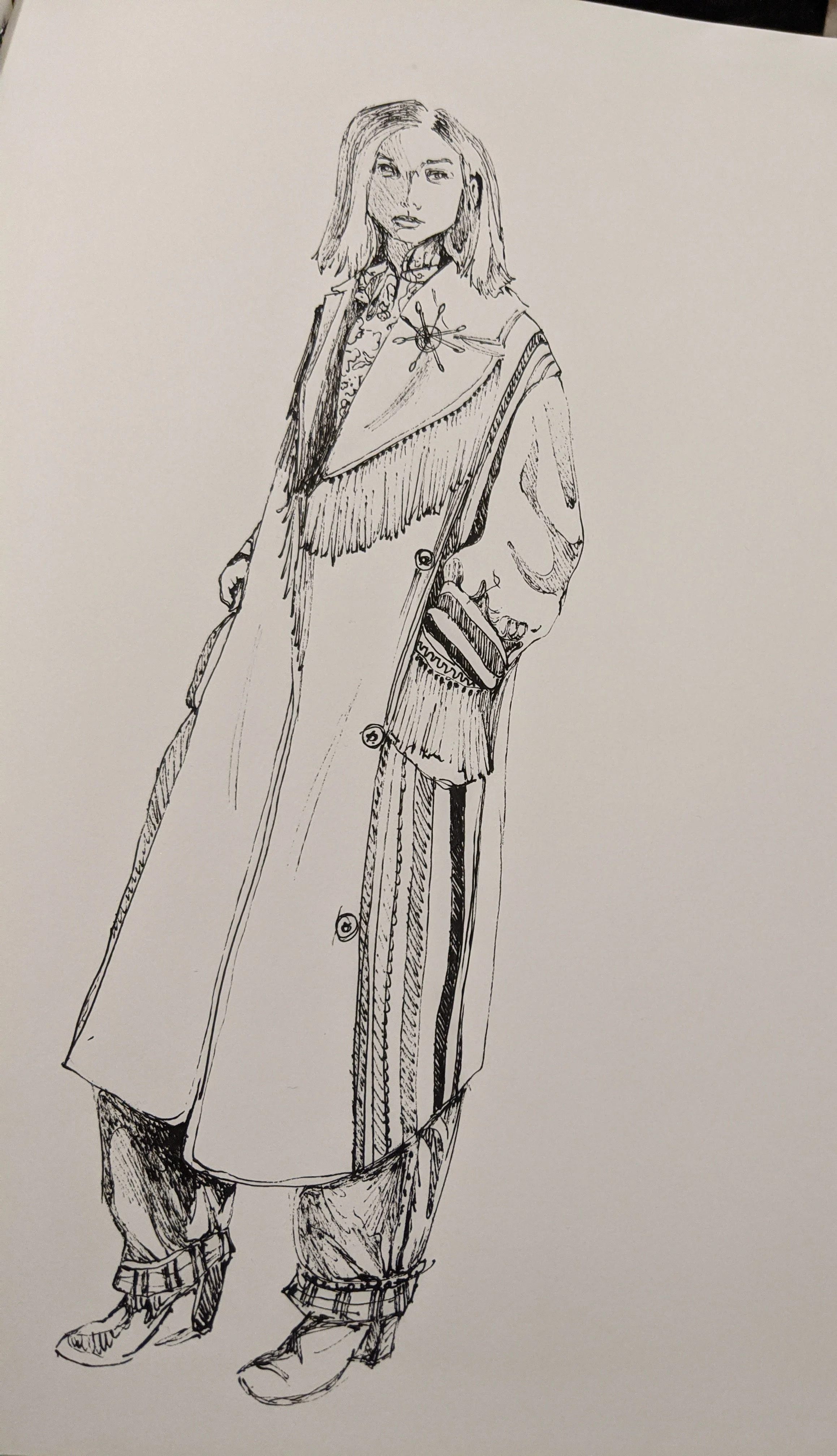 Black and white ink sketch of a woman wearing a long coat, loose pants, and boots, with her left hand in her pocket and her right hand hanging down.