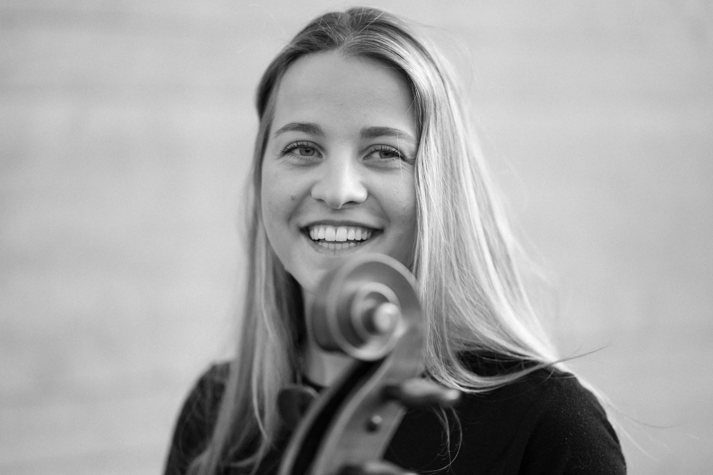 Junge Frau mit Violine, lächelnd, nahaufnahme, schwarz-weiß.