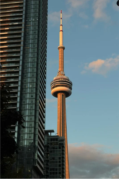 The CN Tower, a tall communications and observation tower, seen in Toronto, Canada, with a clear blue sky in the background.