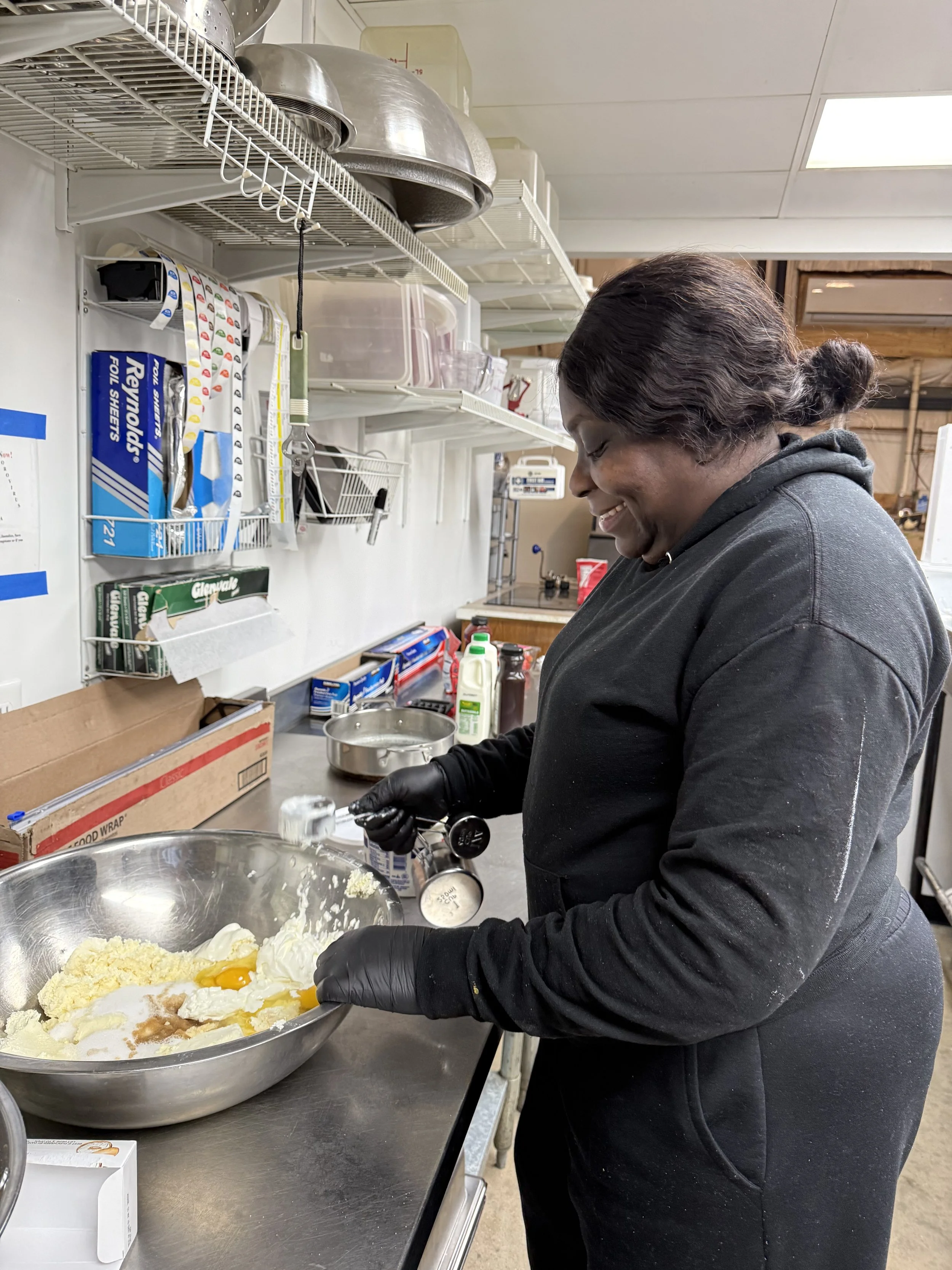 Food entrepreneur preparing ingredients in a commercial kitchen at On The Fly Culinary in Fredericksburg VA, showcasing hands-on food production and kitchen workspace