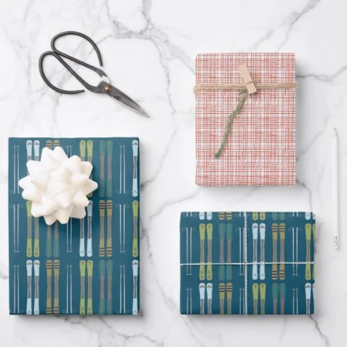 Two wrapped gifts with colorful scarves, a pair of scissors, and a white ribbon bow on a marble surface.