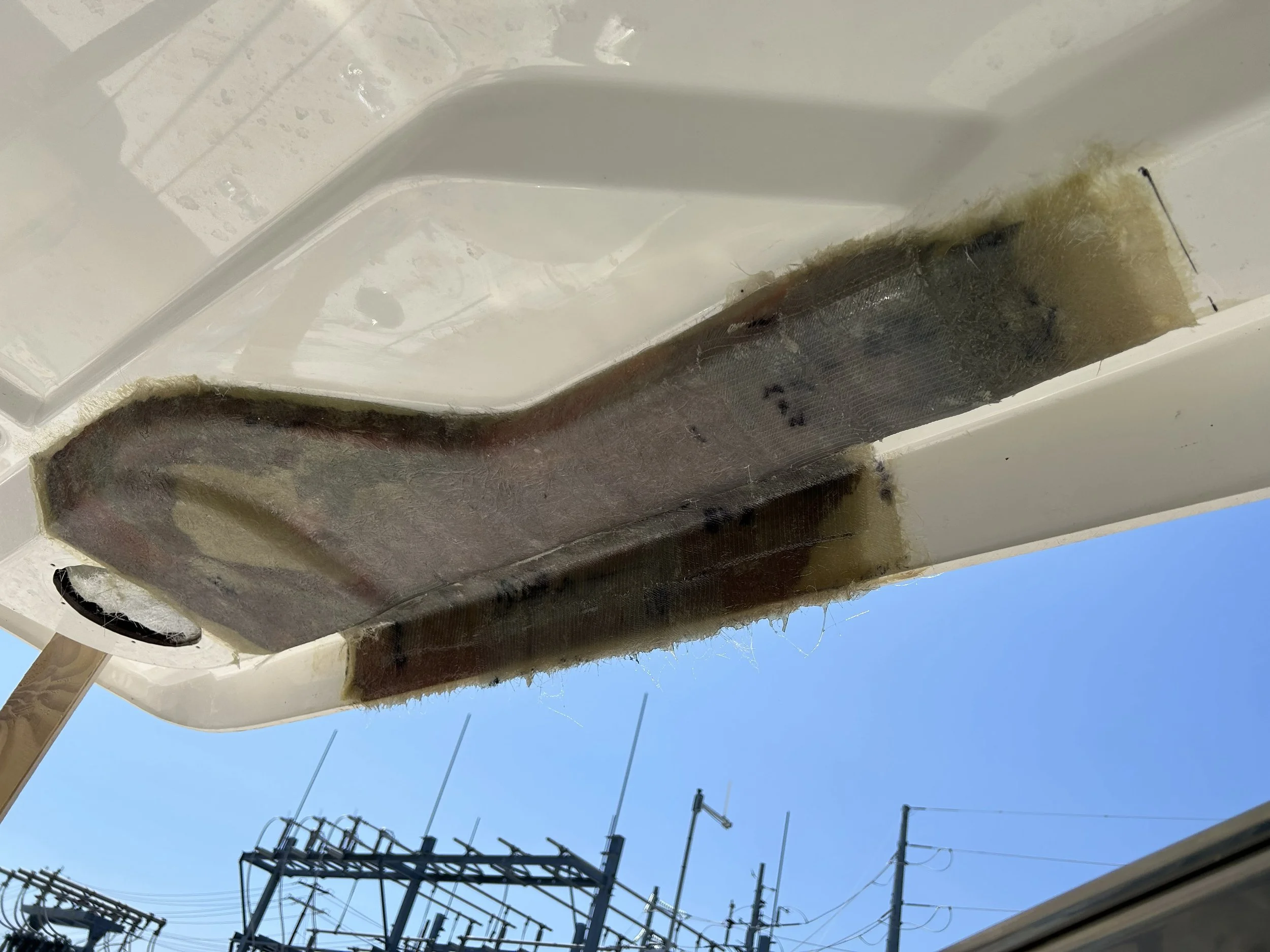Fiberglass repair on top of a boat with repair laminate finished and getting ready for fairing and marine gelcoat paint.
