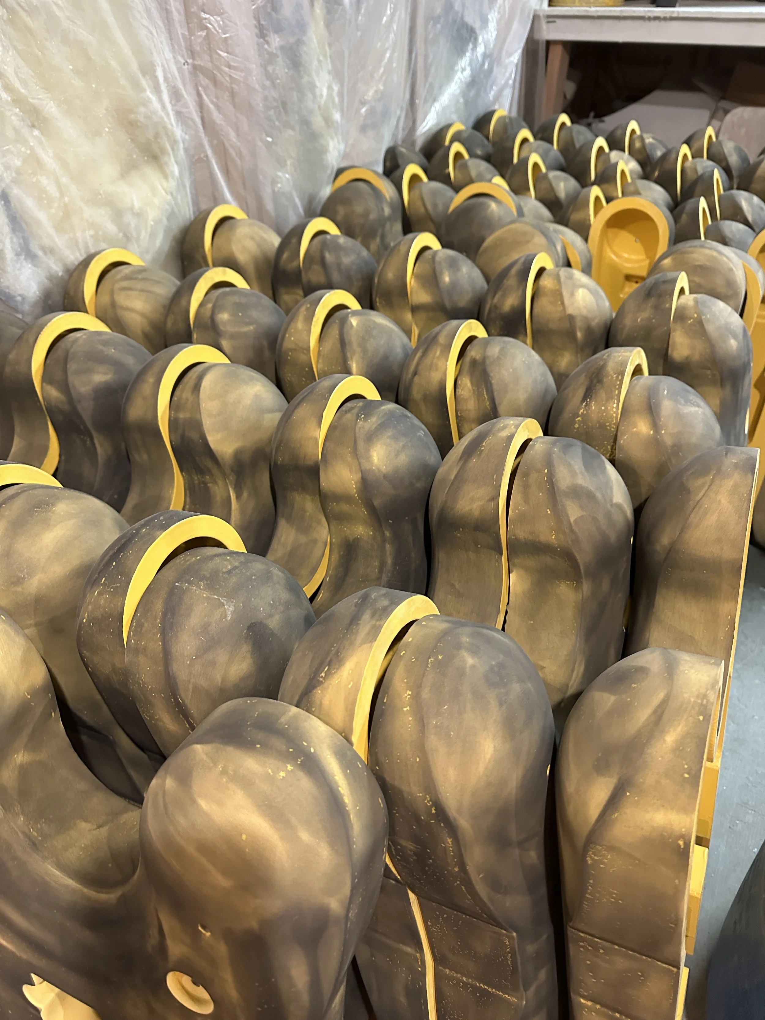 A large number of black and yellow industrial foot valves or similar equipment stacked in a workshop or warehouse.