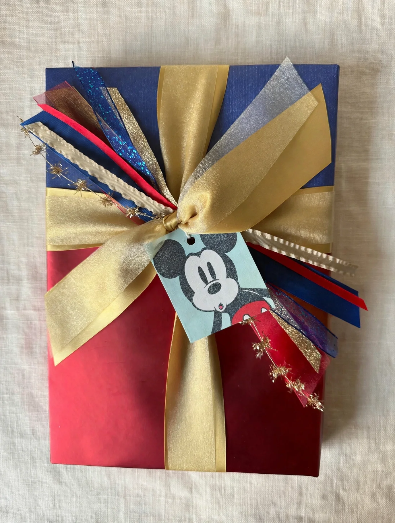 Red gift with layered colorful ribbon and a Mickey Mouse gift tag.