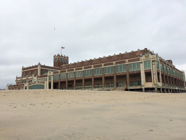 image shows the Asbury Park Convention Hall, a red brick building on the sand