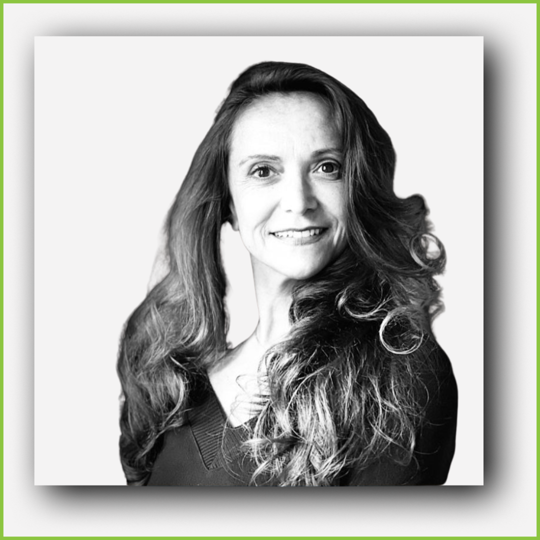 Black and white headshot of a smiling woman with long, wavy hair, wearing a dark top, against a plain light background.