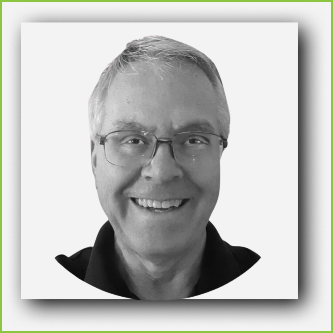 Black and white headshot of a smiling man wearing glasses and a collared shirt.