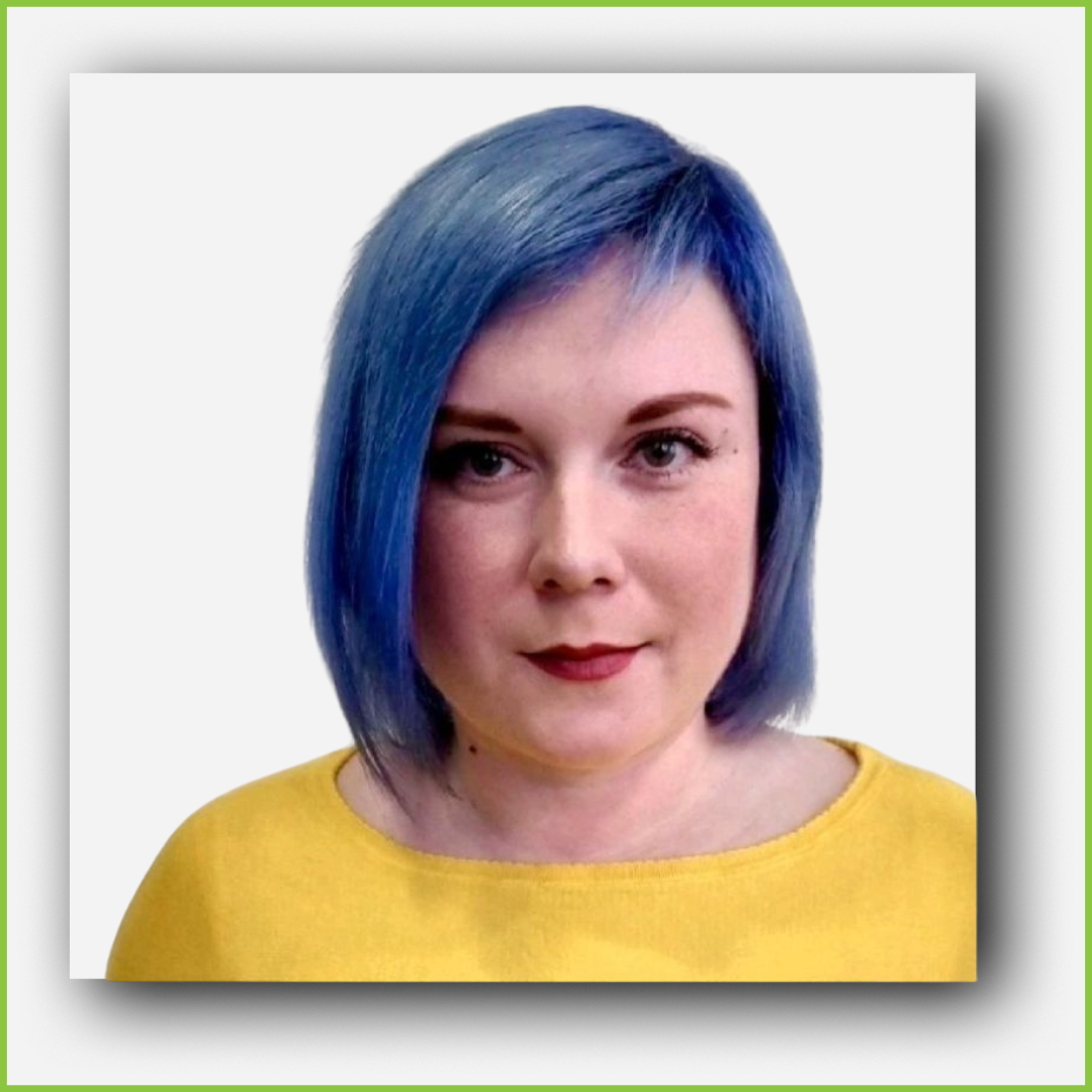 A woman with short, blue hair wearing a yellow top against a plain white background.