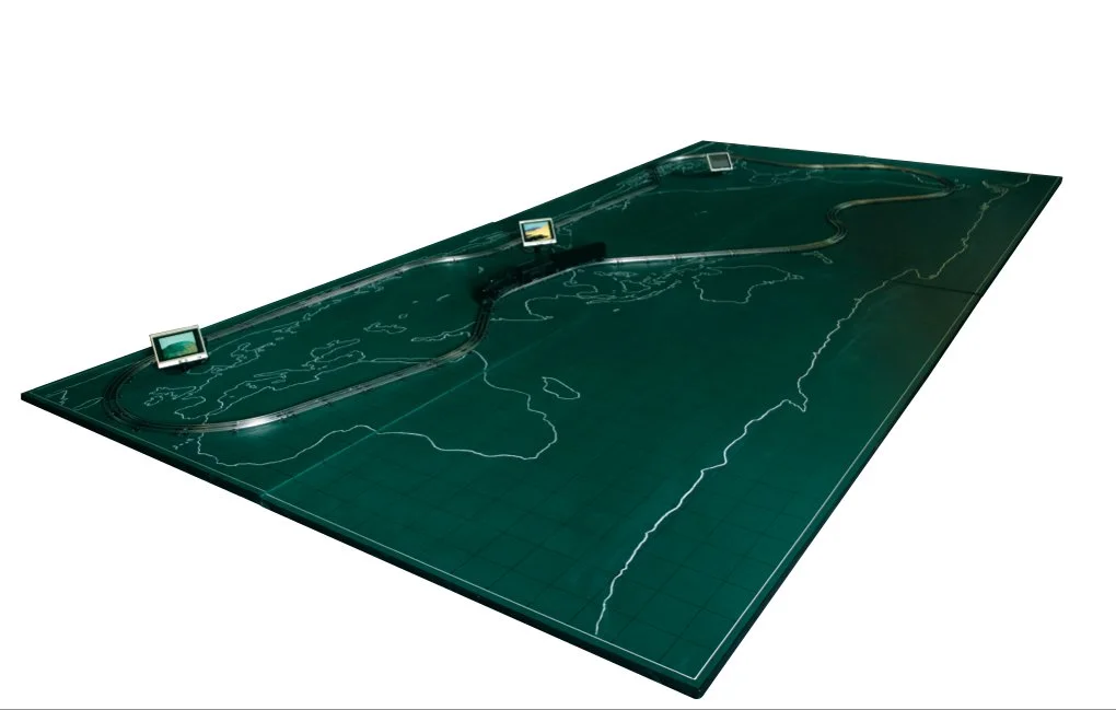 Meta Travel Studio, 2003, Oil pastel on chalkboard, toy train & track, LCD Monitor, 94 1/2 x 189 inches (240 x 480 cm)