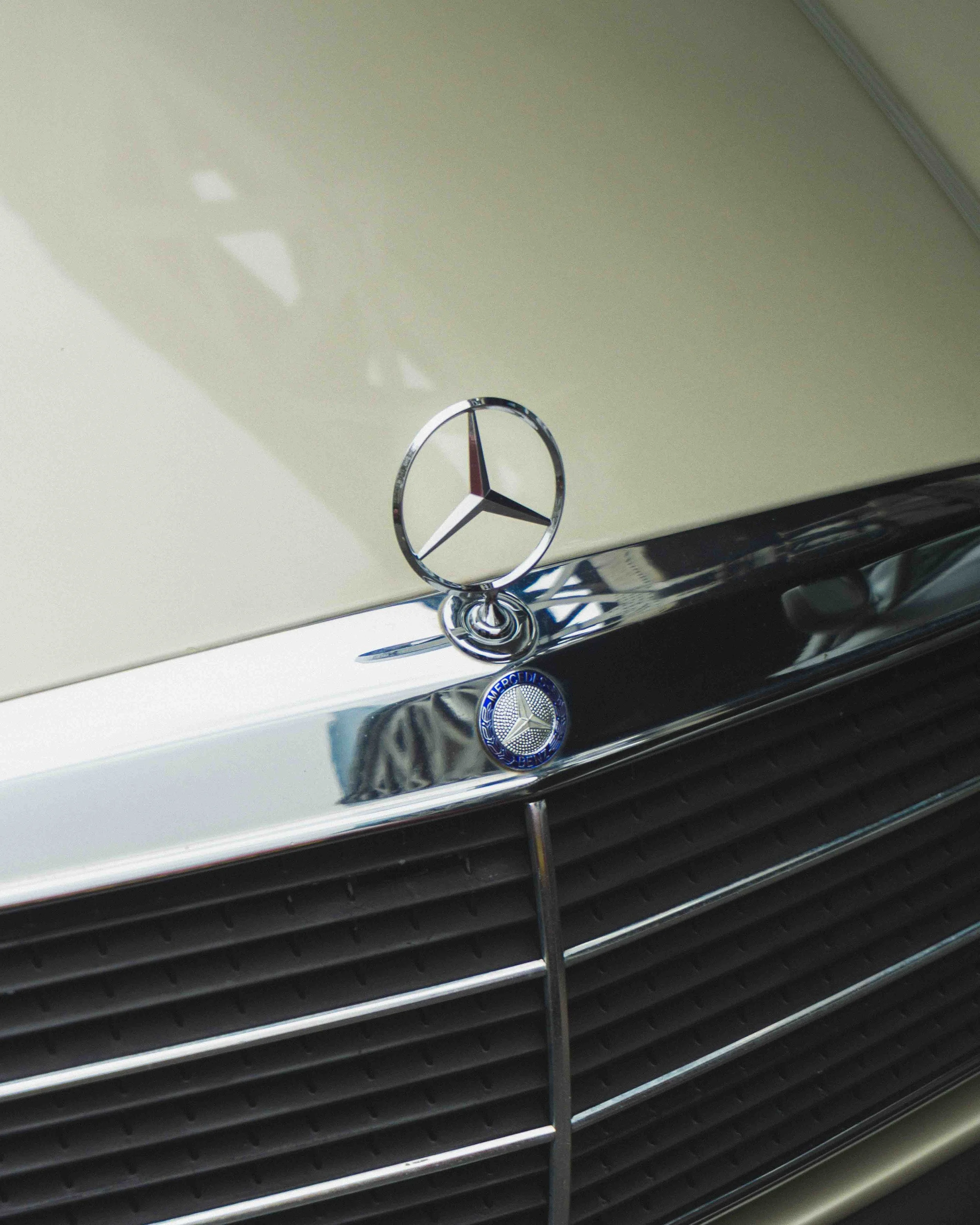 Close-up of the front of a vintage Mercedes-Benz car, showing the iconic Mercedes emblem and grille.