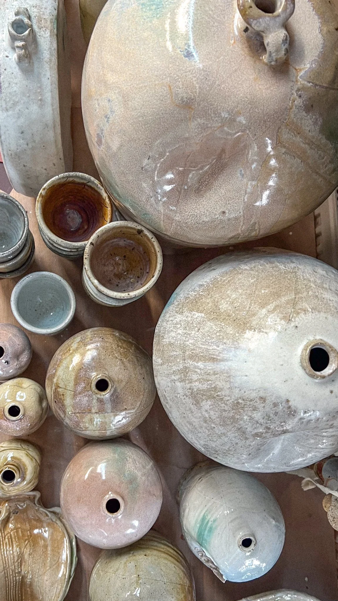 Various ceramic vases and pots with different shapes, sizes, and colors, arranged together on a surface.