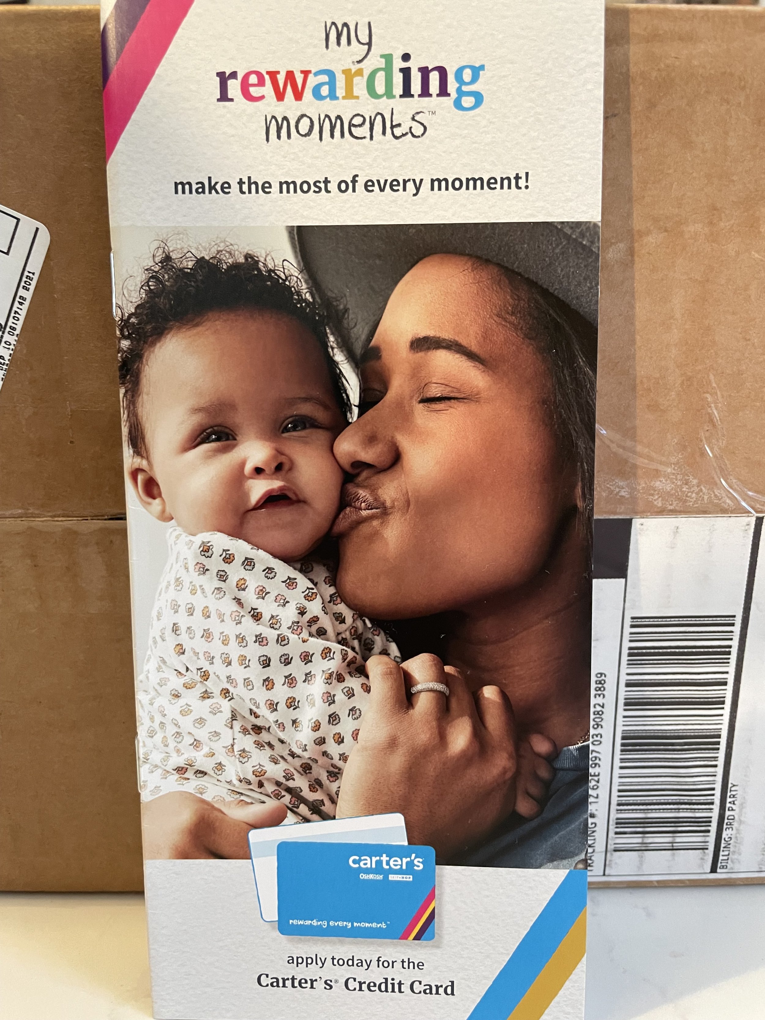 Carter's credit card reward advertisement featuring a woman kissing a young child, both smiling, with text promoting the Carter's credit card and its rewards program.