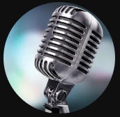 Close-up of a vintage microphone with a black stand against a blurred colorful background.