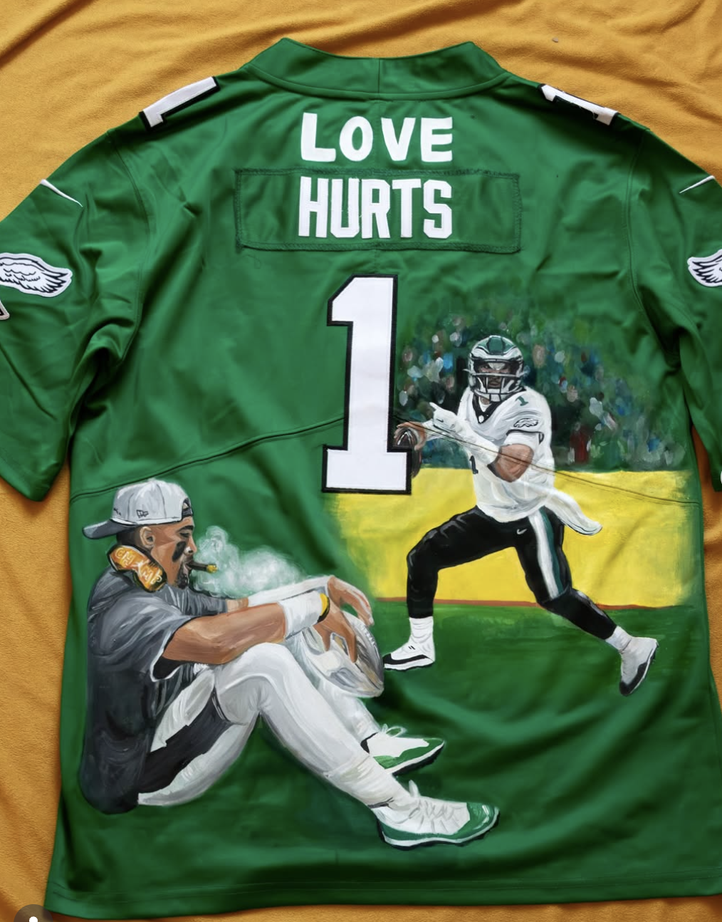 A green football jersey with painted artwork depicting a football player in action and another person relaxing. The jersey has the words 'LOVE HURTS' at the top and a large number '1' in the center.