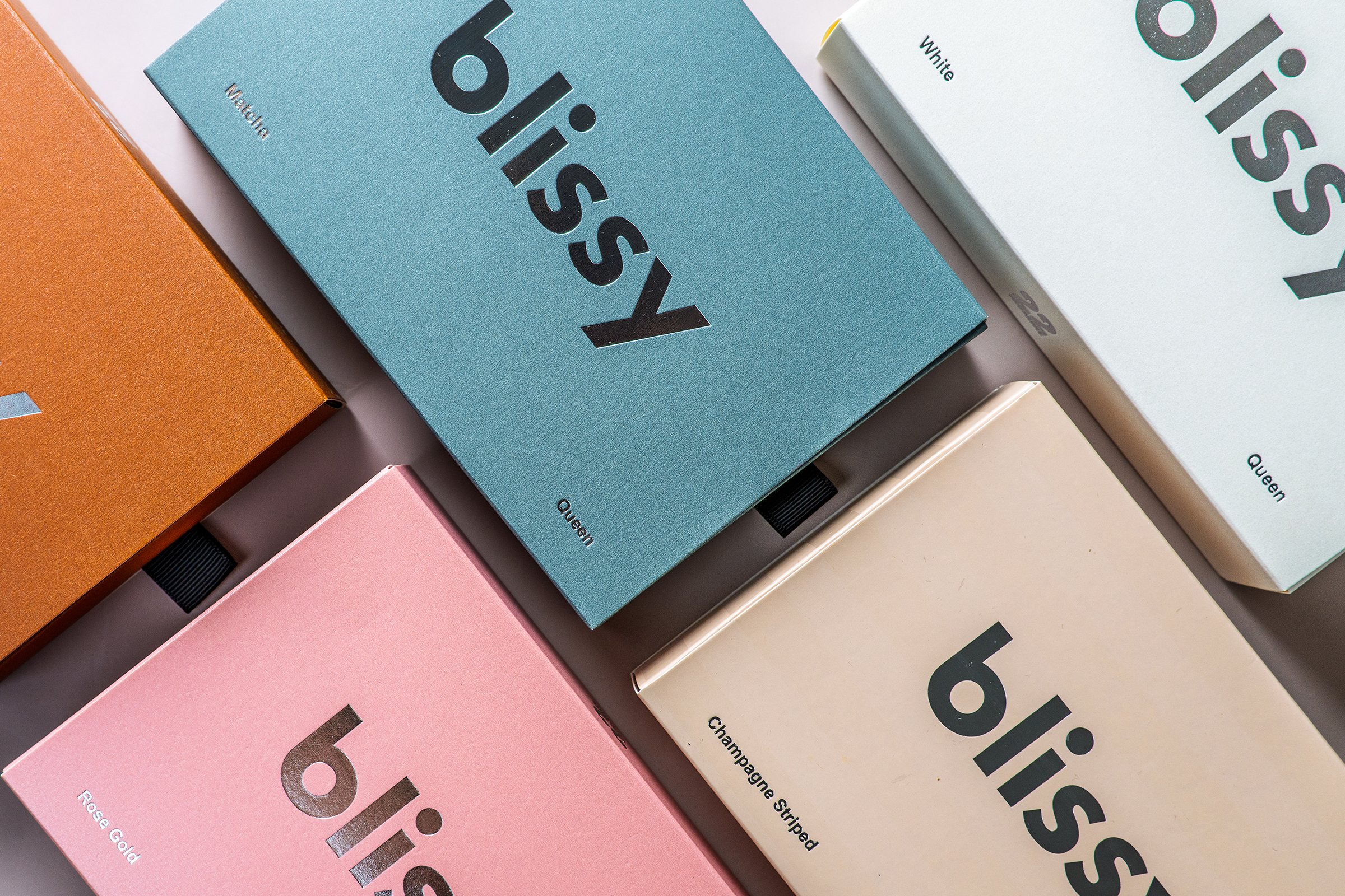 Multiple colorful boxes of Bisous soap with different fragrances and colors, including blue, pink, white, orange, and beige, arranged on a flat surface.