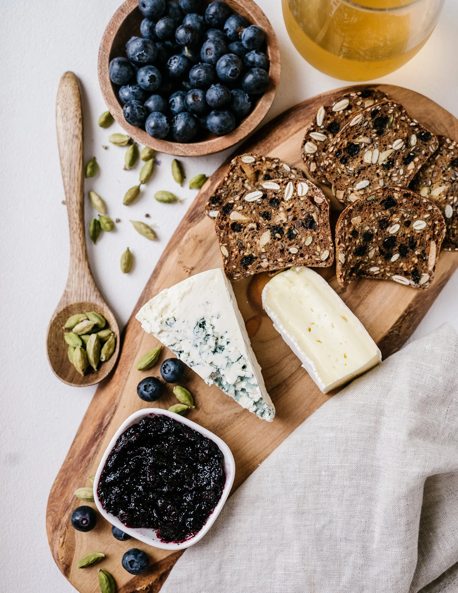Commercial food photography featuring Turtle Rock Farm blueberry preserves with artisan cheeses, fresh blueberries, seeded bread, and rustic styling for a Maine specialty food brand.