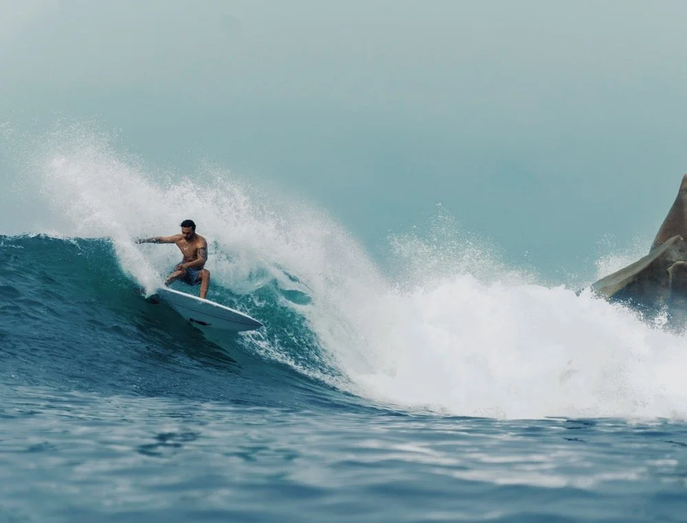 A man surfing on a wave in the ocean.