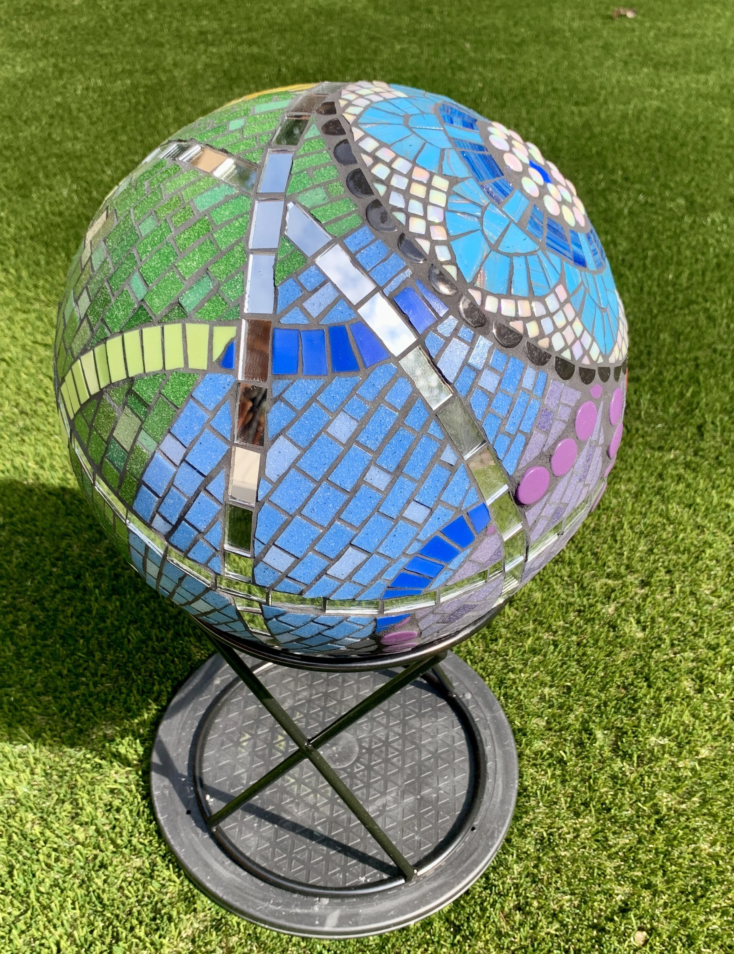 "Universal Intersectional", built on pre-formed 12" styrofoam sphere, covered in mesh and thinset, then tiled in vitreous glass tile and mirror.