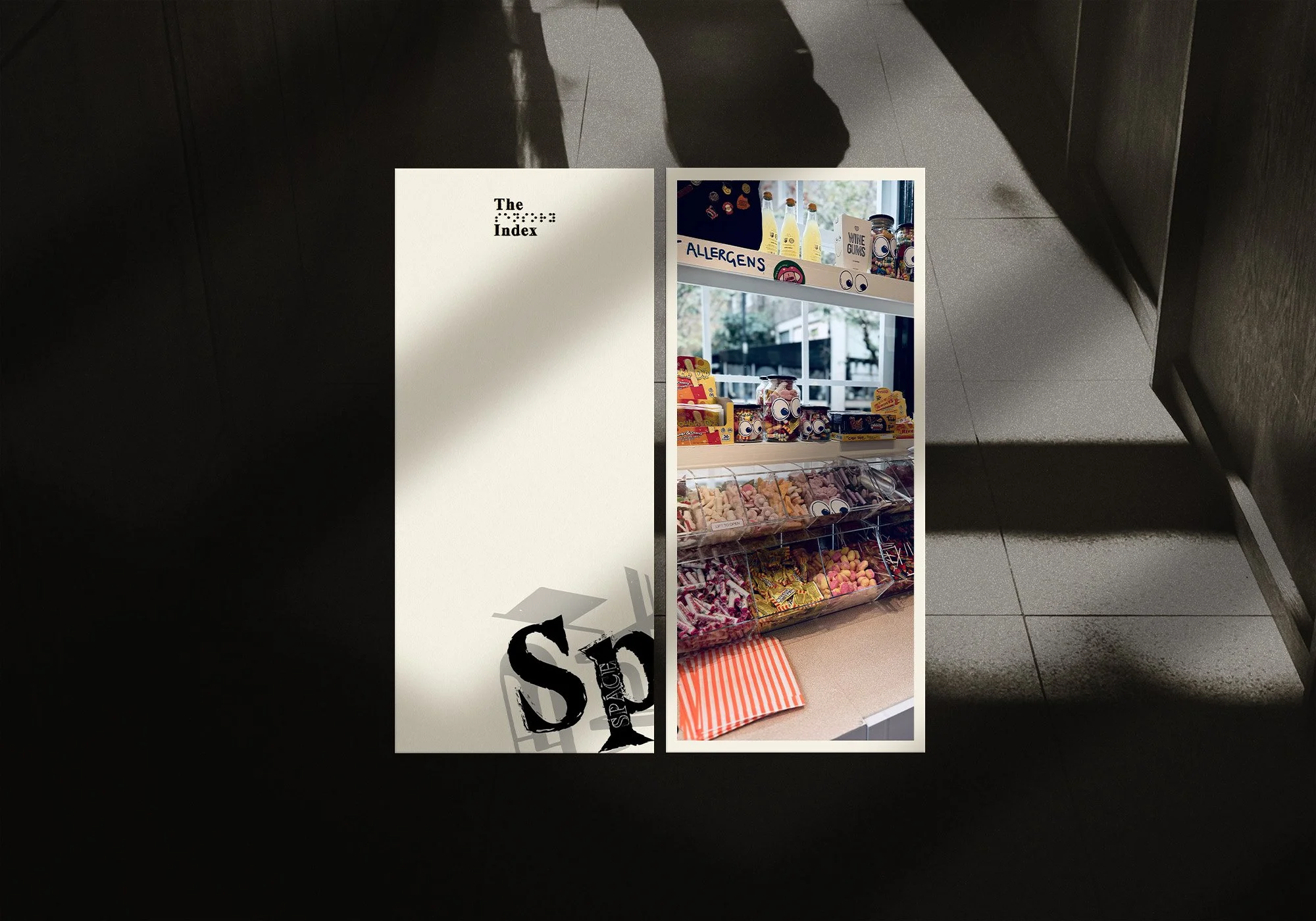 Image of a store display shelf with various colorful candies and snacks, including gummy bears, jars, and packaged candy, with a window and outdoors visible in the background.