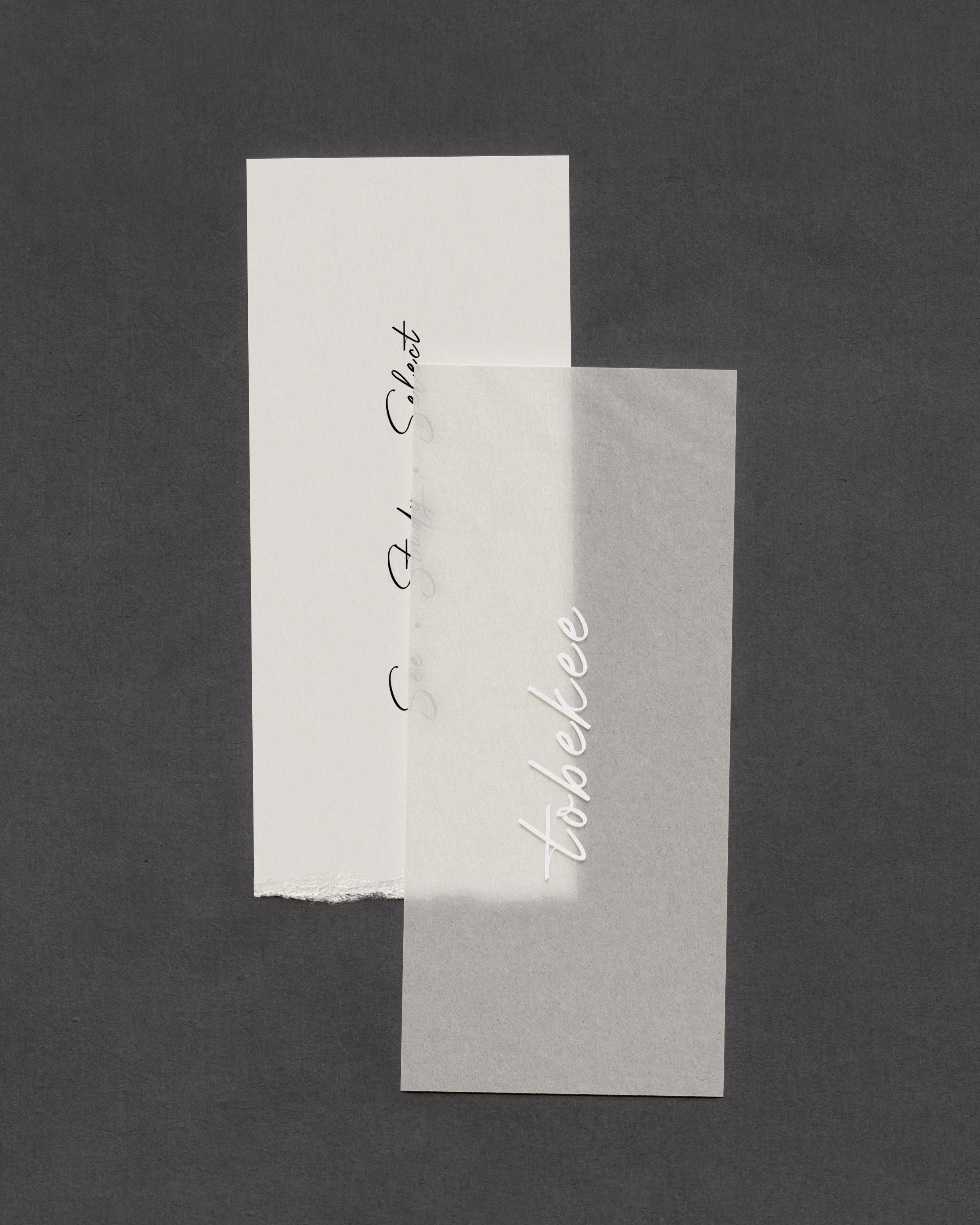 Two pieces of paper, one with the words 'See You Soon' in cursive and the other with 'to be' in cursive, against a dark background.