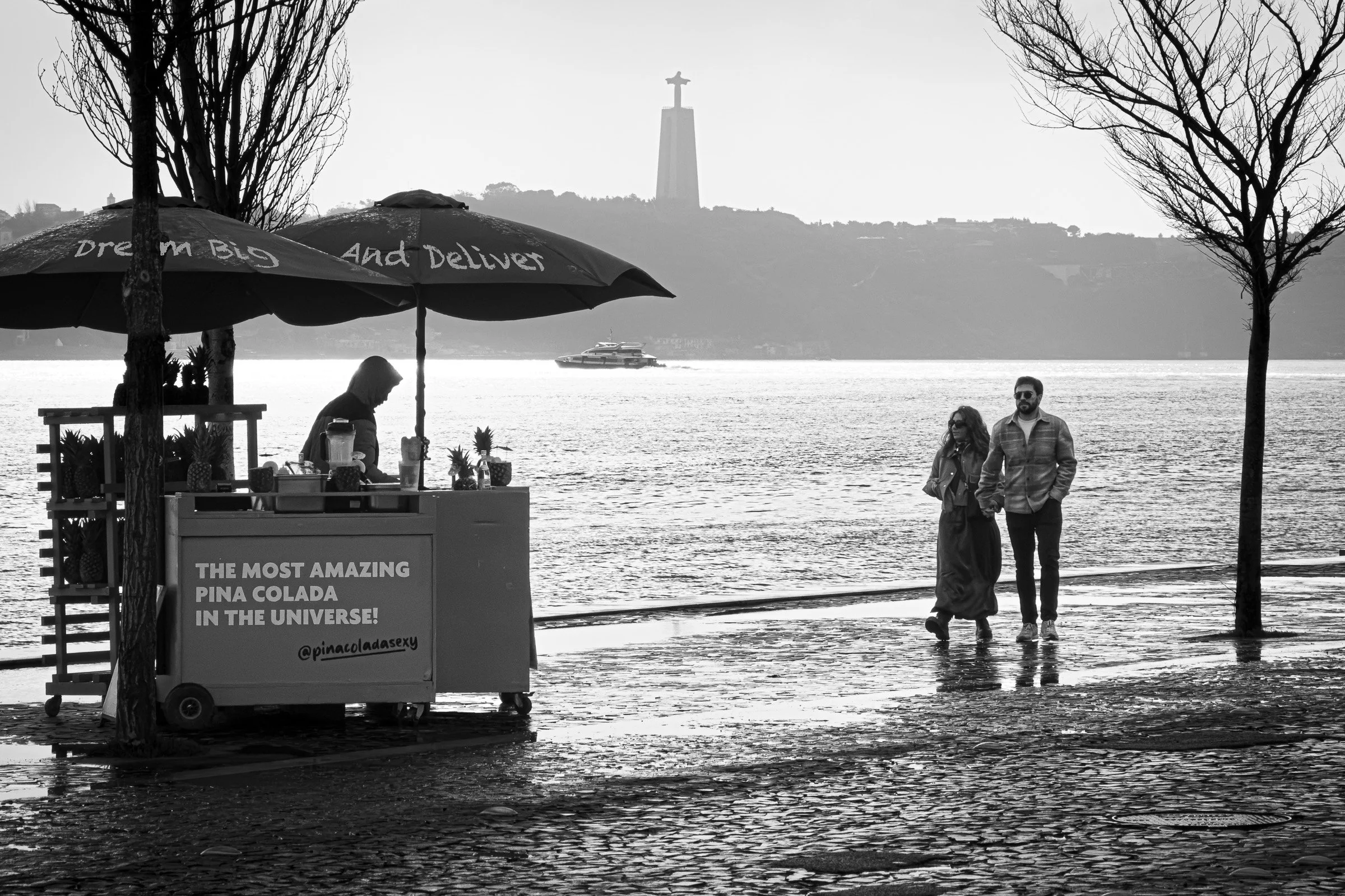 Street vendor serving customers along a waterfront with a large monument visible on the horizon, symbolising the balance between long-term vision and day-to-day execution in business.