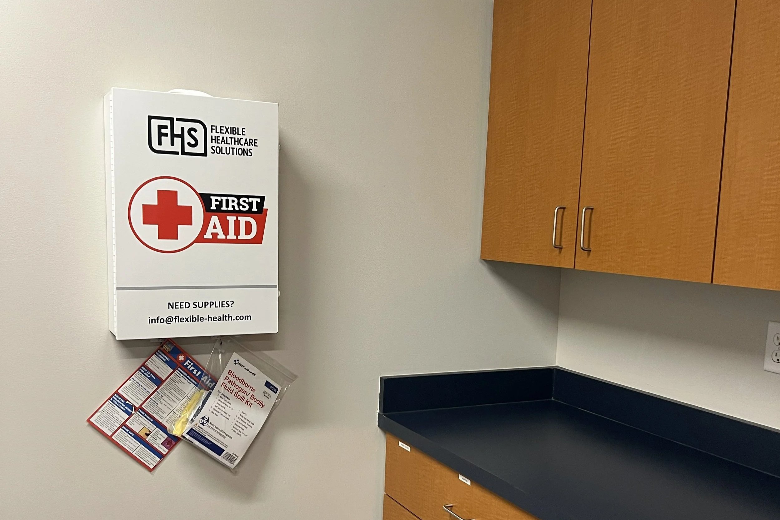 Wall-mounted OSHA compliant first aid cabinet for an office
