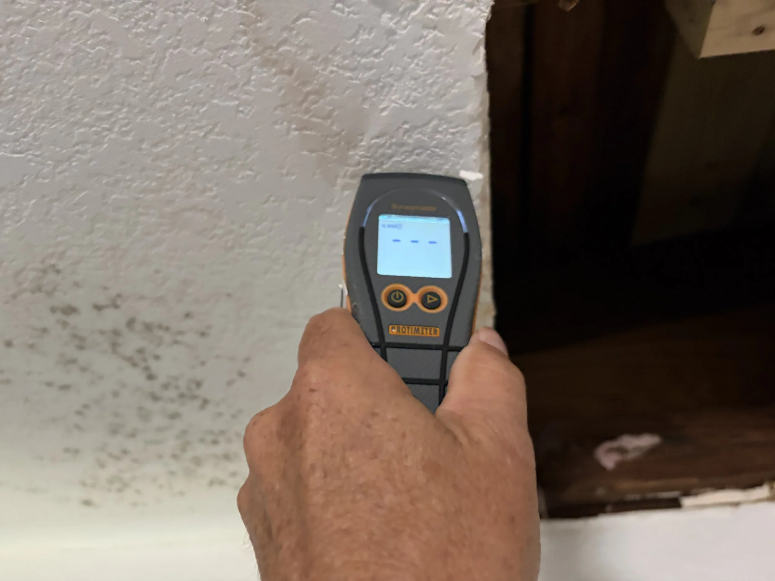 Photo of a moisture meter being used on water damaged drywall with mold in Orlando
